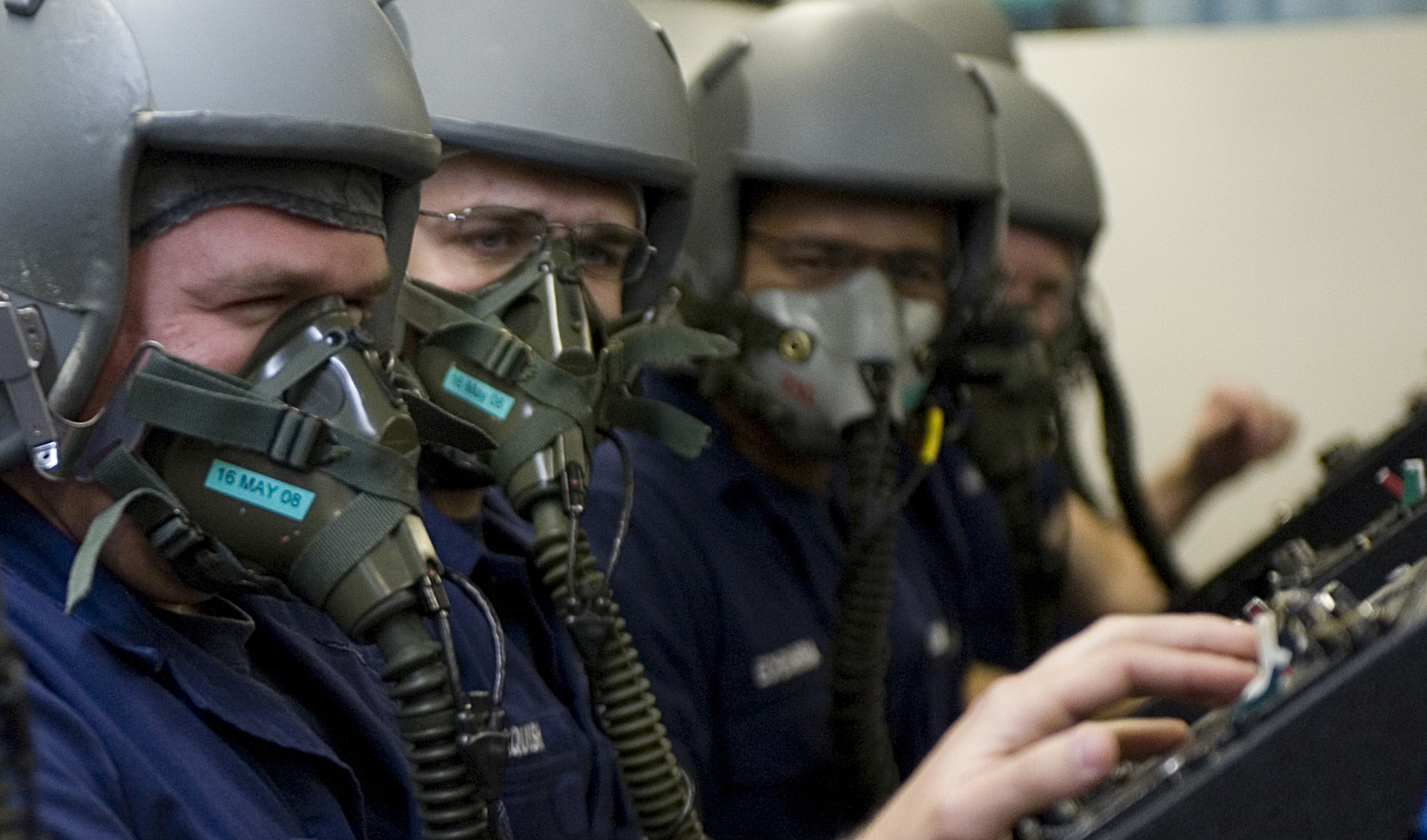 LANGLEY AIR FORCE BASE, Va. -- Airman Larry Kohl (left), a U.S. Coast Guard Aviation Maintenance Technician student from Elizabeth City Coast Guard Station, try's to speak to fellow students while performing a mask test  during altitude chamber training on March 23. While in the altitude chamber students are exposed to atmospheric conditions at 25,000 feet. Without the aid of an oxygen mask they experience symptoms of hypoxia, an oxygen deficiency of the tissue and blood cells that causes impairment of function at high altitudes. (U.S. Air Force Photo/Staff Sgt. Samuel Rogers)
