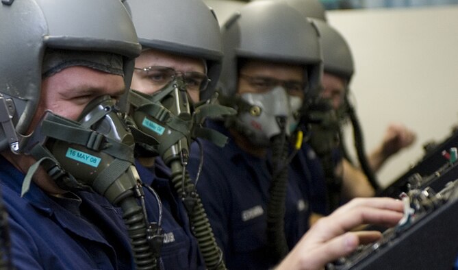 Students perform a mask test during altitude chamber training in 2008. The students are trained to recognize symptoms of hypoxia, an oxygen deficiency of the tissue and blood cells that causes impairment of function at high altitudes. (U.S. Air Force photo)