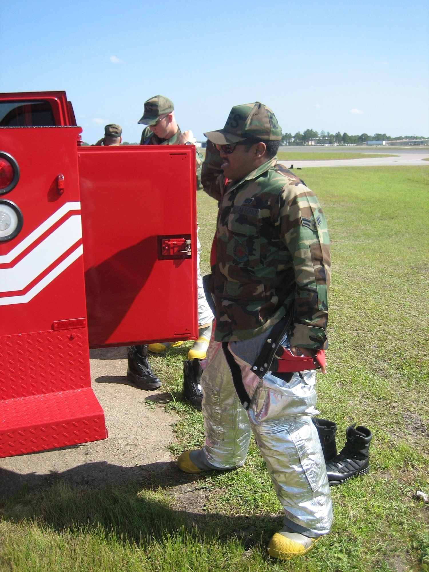 Airman 1st Class Douglas White, 325th Civil Engineer Squadron fire protection specialist, quickly dons fire protection equipment before racing to the scene of a simulated plane crash. Tyndall fire fighters and medical personnel participated in a joint training exercise with Bay County emergency response agencies April 25 at the Panama City Airport. 