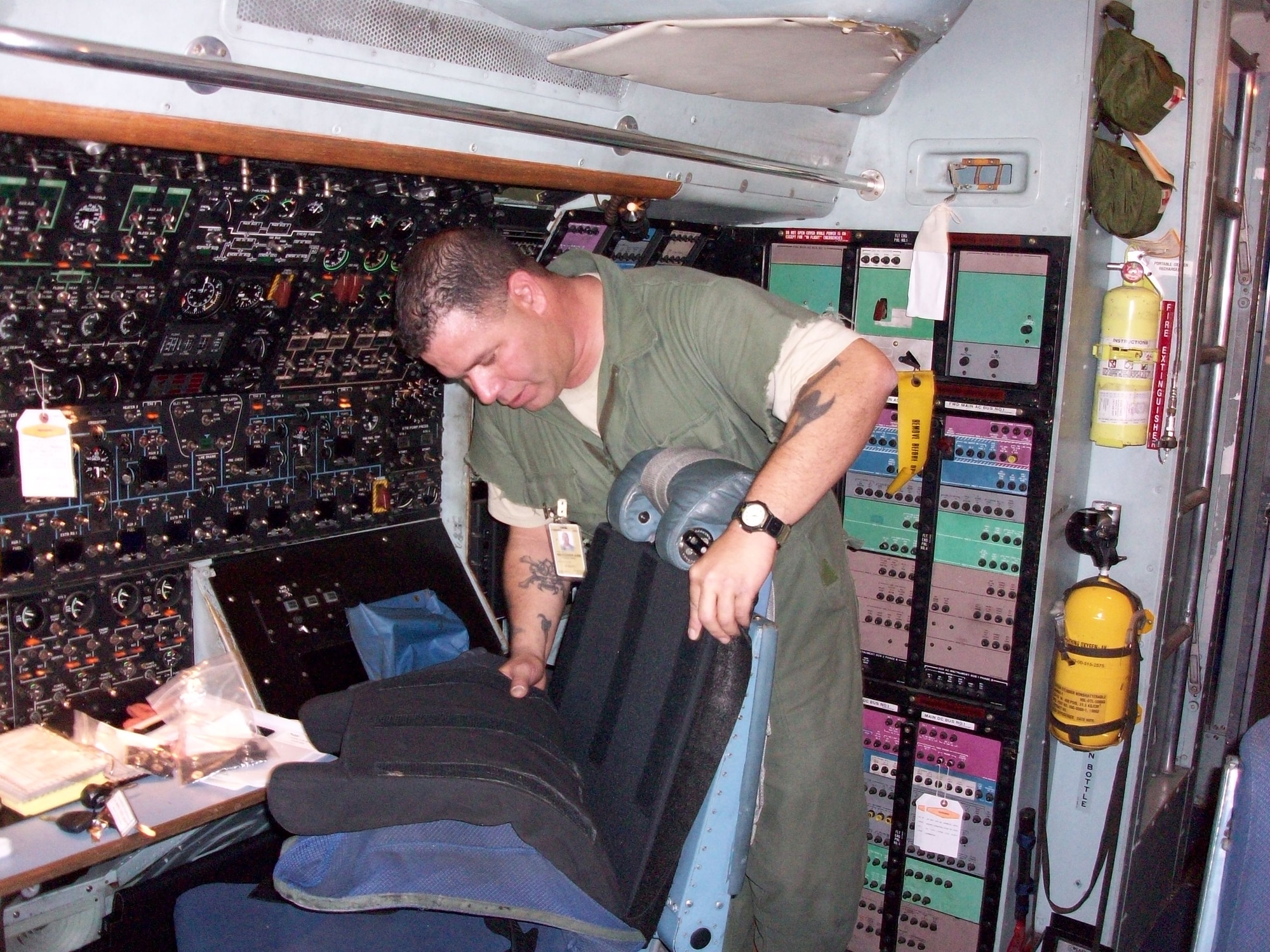 MSgt. Rick Fujimoto, a crew chief with the 653rd combat Logistics Support Squadron, installs battle armor to the pilot's seat of a C-5 Galaxy.