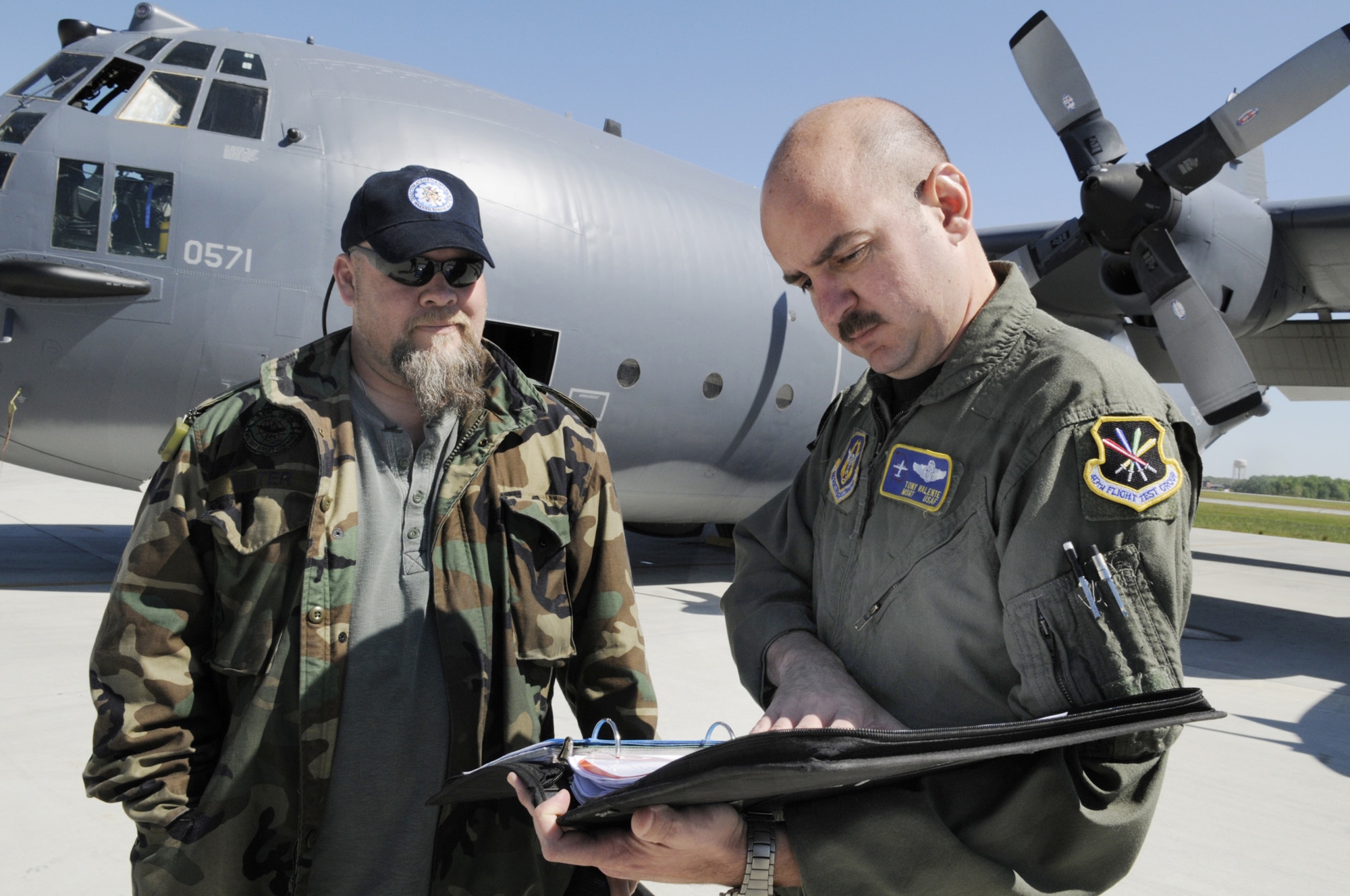 Eddie Minter, C-130 functional test work lead, mets with MSgt. Tony Valente, flight engineer to look over work records before a testflight of an MC-130E. U. S. Air Force photo by Sue Sapp