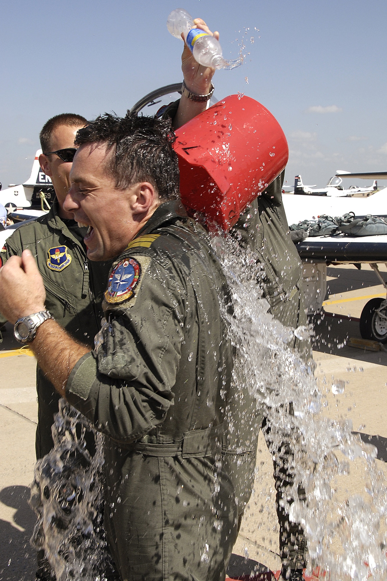 Cmdr. German Navy Peter Schroth is given a ceremonial dousing by fellow pilots following his final flight with the Euro-NATO Joint Jet Pilot Training Program April 24. Commander Schroth's retirement marks the end of figher-bomber pilots in the German navy, as well as the participation of the country's navy pilot in ENJJPT. (U.S. Air Force photo/Harry Tonemah)
