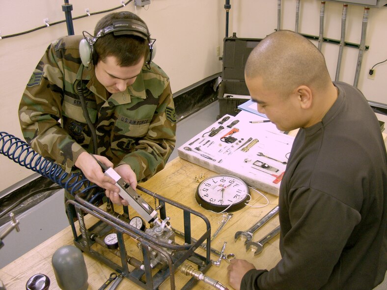 Staff Sgt. Charles Remele, 90th Maintenance Operations Squadron, and Senior Airman Danilo Dancel, 90th MOS, test each other's job knowledge (U.S. Air Force Photos).