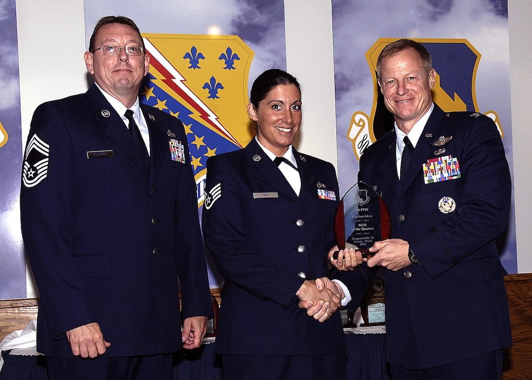 Staff Sgt. Ingrid Ivey, 80th Operations Support Squadron, accepts the NCO of the Quarter award from 80th Flying Training Wing Commander Col. David Petersen April 22 during the wing's quarterly award ceremony. Sergeant Ivey was recognized for having a 98 percent quality assurance rating on more than 400 parachutes, oxygen connectors and other flight equipment. Sergeant Ivey also led the way for other OSS personnel to provide community support to the Center for Animal Research and Education. Also pictured is 80th FTW Superintendent Chief Master Sgt. Norman Theirolf. (U.S. Air Force photos/Harry Tonemah)