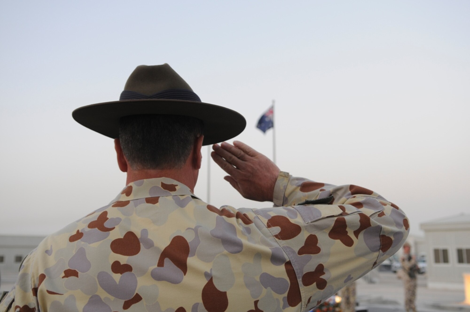 Australian Air Force, Warrant Officer Disciplinary, David Toohey, 633.4 Task Group, renders a salute during the dawn Australia New Zealand Army Corps (ANZAC) day memorial cermony here April 25.  This ANZAC day marks the 93rd anniversary of the first major military action fought by the ANZACS during World War I.
 (U.S. Air Force photo/2nd Lt. Tania Bryan)