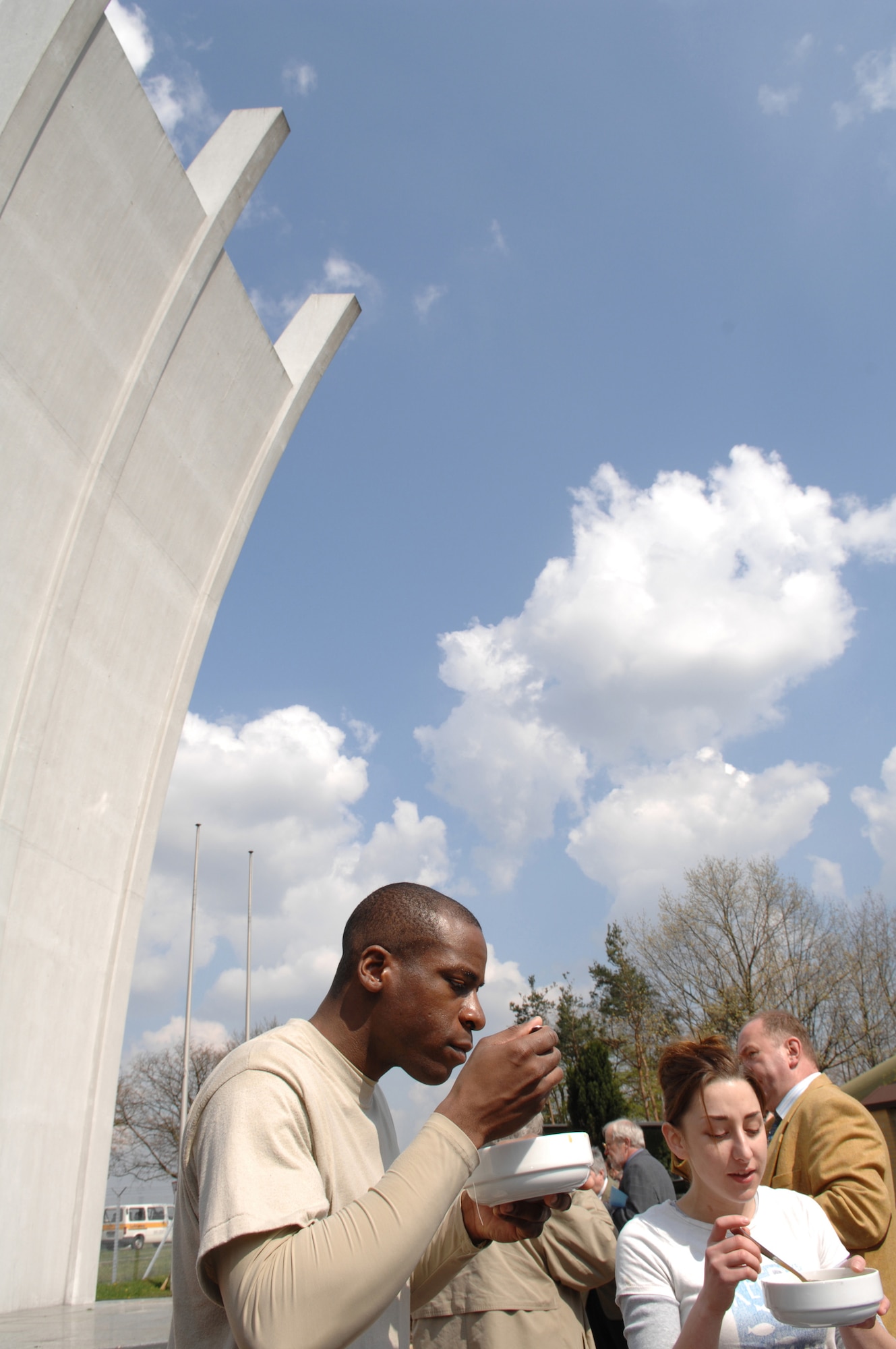 Staff Sergeant Jason Webb and Senior Airman Lindsey Arotin enjoy lunch provided by Fraport AG, the agency who operates the Frankfurt International Airport, during a day of cleaning the static aircraft displays at the Berlin Airlift Memorial site at the former Rhein Main Air Base in Germany.  Approximately thirty Airmen from Ramstein Air Base volunteered for the three day project to help Fraport and Luftansa Technik volunteers prepare for a Berlin Airlift 60th Anniversary celebration in June. (U.S. Air Force photo by Tech Sergeant Corey Clements)