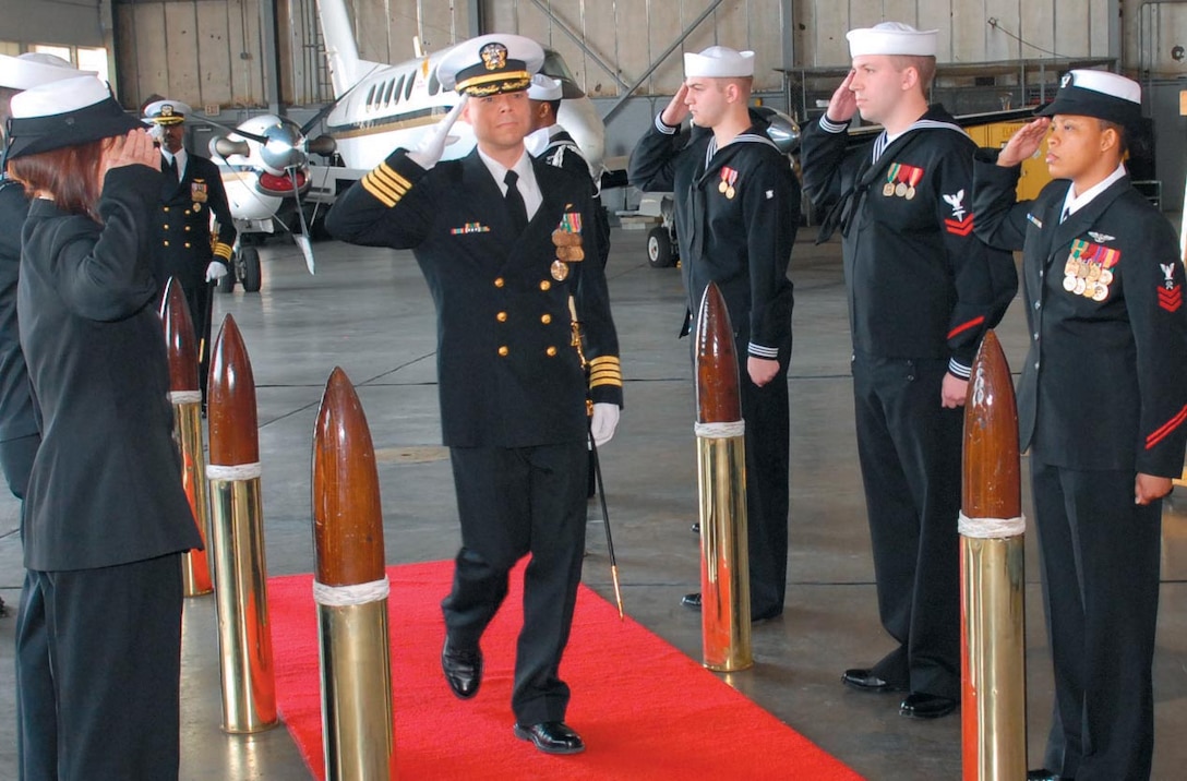 Navy Capt. Timothy R. Fox, Naval Air Facility Washington commanding officer, renders a salute as he passes through a cadre of sideboys during the change of command ceremony held here on April 19. Captain Fox assumed command from Capt. Marcus J. Cromartie.
