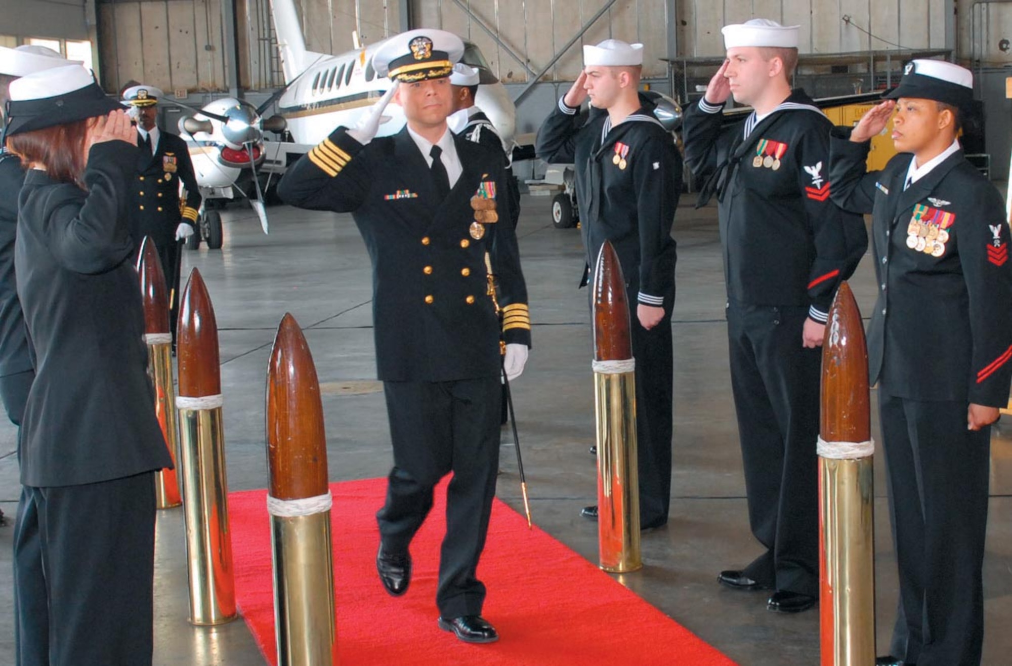 Navy Capt. Timothy R. Fox, Naval Air Facility Washington commanding officer, renders a salute as he passes through a cadre of sideboys during the change of command ceremony held here on April 19. Captain Fox assumed command from Capt. Marcus J. Cromartie.