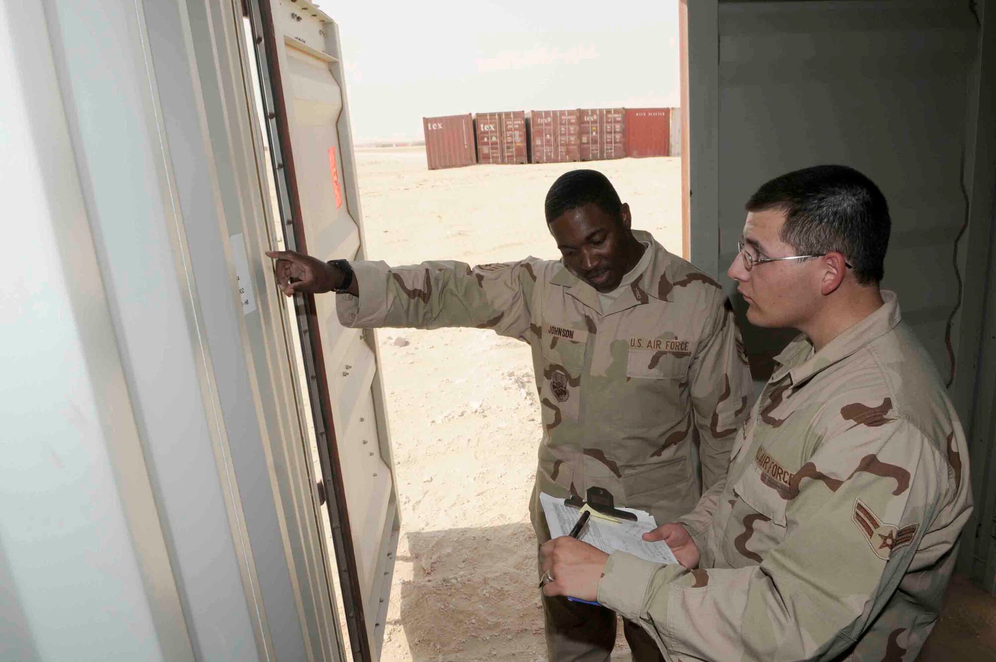 Airman 1st Class Joseph Trevino and Staff Sgt. Maurice Johnson, 379th ELRS, match container numbers to paperwork to ensure the correct container is shipped.  (U.S. Air Force photo by Tech. Sgt. Johnny Saldivar.)