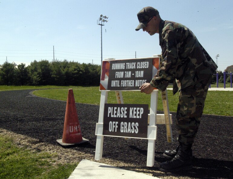 Staff Sgt. Matthew Novak, 436th Civil Engineer Squadron, puts the sign out that the Base Track is closed from 7 to 10 a.m. to reseed the field. The 436th CES are currently hydro-seeding for the field. (U.S. Air Force photo/Airman 1st Class Shen-Chia Chu)
