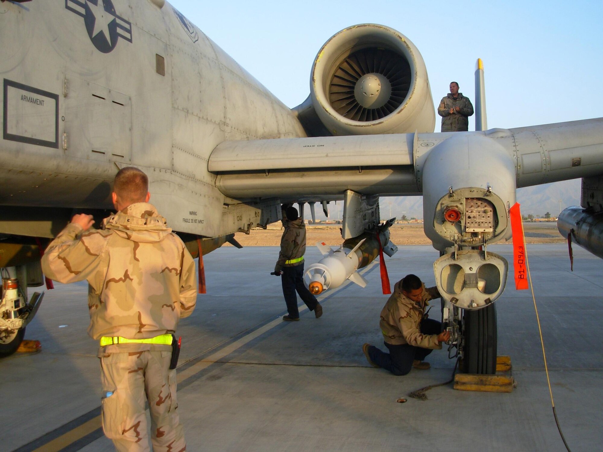 BAGRAM AIR BASE, Afghanistan – During a thru-flight inspection, Senior Airmen Justin Lovejoy and Mike Pena examine the fuselage of an A-10 Thunderbolt II while Staff Sgt. Isaac Ibarra inspects the breaks. On the wing, Staff Sgt. Shawn Mercier performs an intake and exhaust inspection on the Warthog's engine. The crew chiefs are all deployed from Spangdahlem Air Base, Germany.  (U.S. Air Force photo/Master Sgt. Tom Bivens)