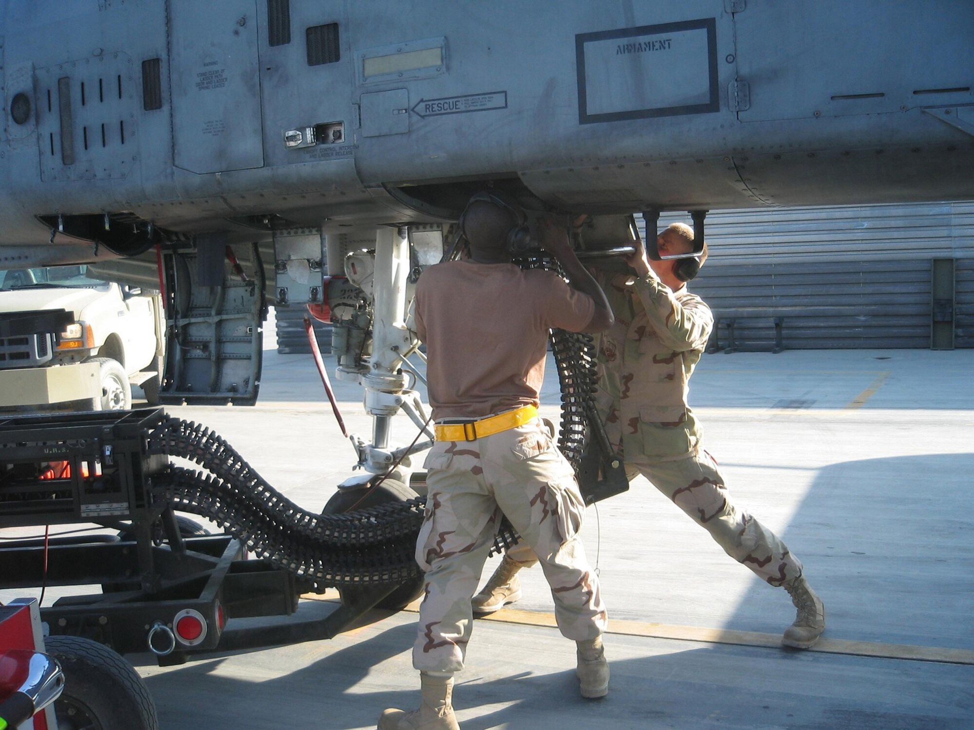 BAGRAM AIR BASE, Afghanistan – (Left to right) Staff Sgt. Jakonise Jones and Airman Nicholas Giacomino connect an ammunition loading adaptor to the gun system of an A-10 Thunderbolt II. They are preparing to reload the Warthog with 30 mm ammunition. The Airmen are both deployed from Spangdahlem Air Base, Germany.  (U.S. Air Force photo/1st Lt. Kristen Lainis)