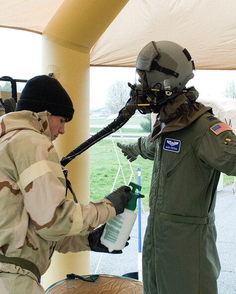 Airman Kevin Robinson, 436th Operations Support Squadron, sprays aircrew member Capt. Mark Freitas, 9th Airlift Squadron, with a simulated bleach and water solution at station 3. (U.S. Air Force photo/Roland Balik)