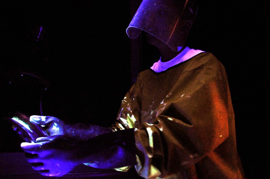 SOUTHWEST ASIA—Senior Airman Cori Lester, 379th Expeditionary Maintenance Squadron non-destructive inspections specialist, examines an aircraft using penetrant underneath a black light in Southwest Asia April 23. As part of their inspections, non- destructive inspections journeymen must check for surface and sub-surface damage according to a technical order for each plane. (U.S. Air Force photo/ Senior Airman Domonique Simmons)