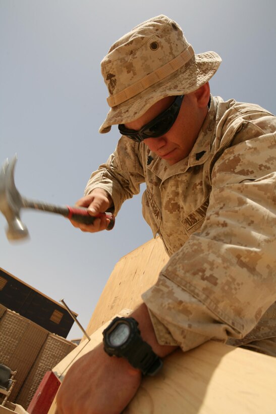 Corporal Nicholas L. Szczerba, 22, a rifleman from Shingle Springs, Calif., assigned to 3rd Battalion, 4th Marine Regiment, Regimental Combat Team 5, builds a door for an interpreter at Combat Outpost Hadith, Iraq, April 25. Szczerba is using the skills he learned doing mission work to assist Marines aboard COP Haditha. Prior to joining the Marine Corps, Szczerba traveled to other countries in the world with his church to build home homes for poor families.