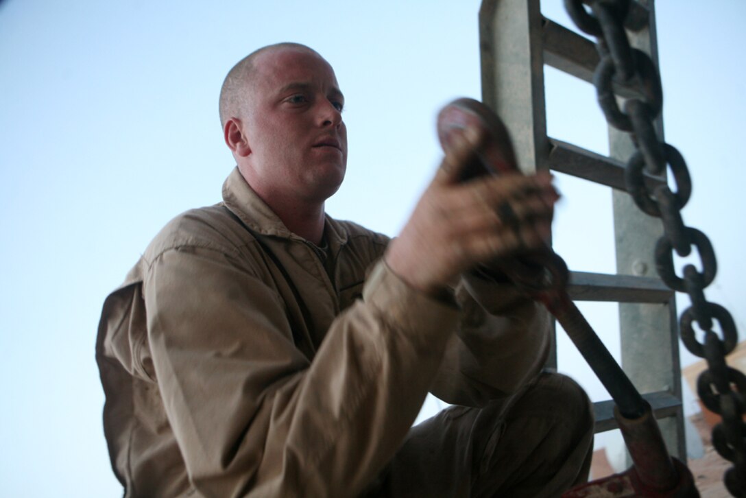 Fastening down a damaged light armored vehicle, Sgt. Jeremy C. Wilhoit, a section leader with Motor Transport Platoon, 2nd Light Armored Reconnaissance Battalion, Regimental Combat Team 5, prepares to deliver the damaged vehicle to a repair facility during a recovery mission in western Anbar province, Iraq, April 25. The members of the wrecker team provide road side service around Anbar province to keep Marines mission set on the road towards peace and stability within the region.