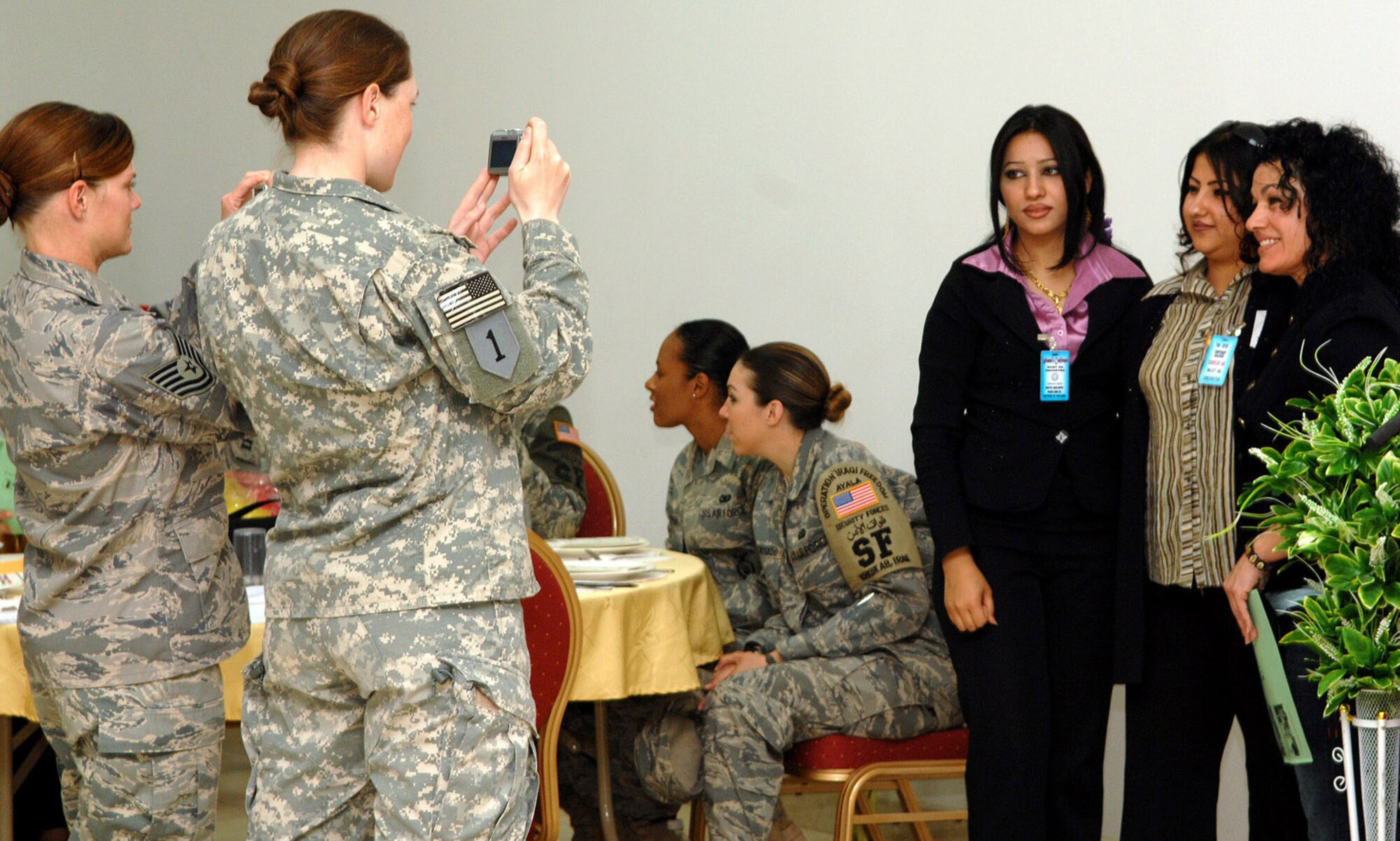 A Soldier and Airman take pictures at the first Northern Iraq Women's Conference held at Kirkuk Regional Air Base April 20. First of its kind in the region, the conference brought close to 100 female Iraqis throughout the Kirkuk Province and U.S. professionals to include female Peshmerga Soldiers from Sulayminiyah, and U.S. Army and Air Force personnel stationed here together. (U.S. Air Force photo by Senior Airman SerMae Lampkin)
