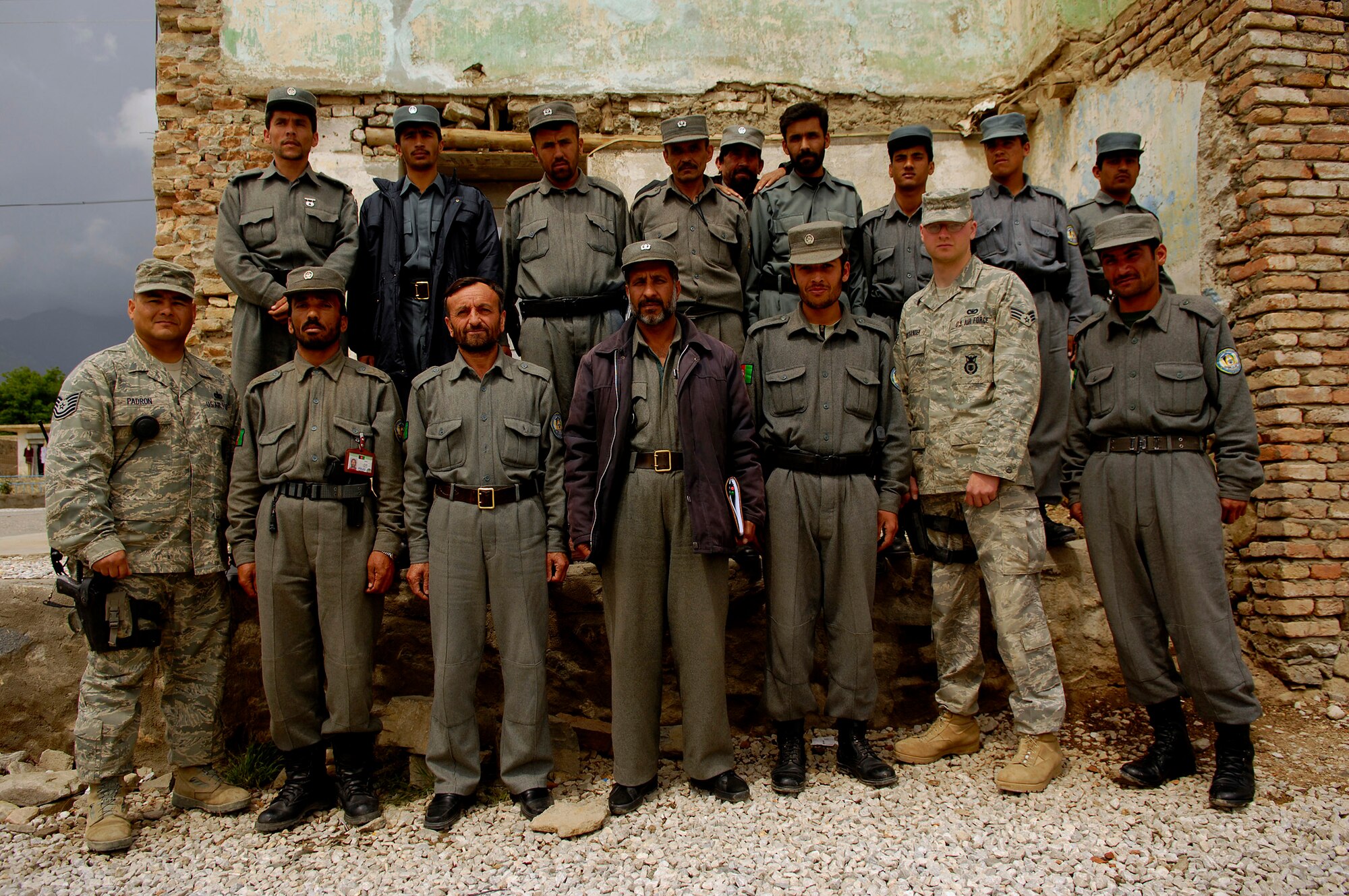 PARWAN PROVINCE, Afghanistan - Tech. Sgt. Christopher Padron and Senior Airman Mark Ostrander stand with members of the Afghan National Police at the Parwan Provincial ANP Headquarters in the Charikar district April 22.  Sergeant Padron and Airman Ostrander provided the ANP with training focused on community policing and conducting field interviews.  Sergeant Pardon, NCO-in-charge Bagram Police Technical Advisory Team, Bagram Provincial Reconstruction Team, is deployed from the 27th Special Operations Security Forces Squadron, Cannon Air Force Base, N.M. Airman Ostrander, PTAT member, Bagram PRT, is deployed from the 55th Security Forces Squadron, Offutt Air Force Base, Neb. (U.S. Air Force photo by Master Sgt. Andy Dunaway)