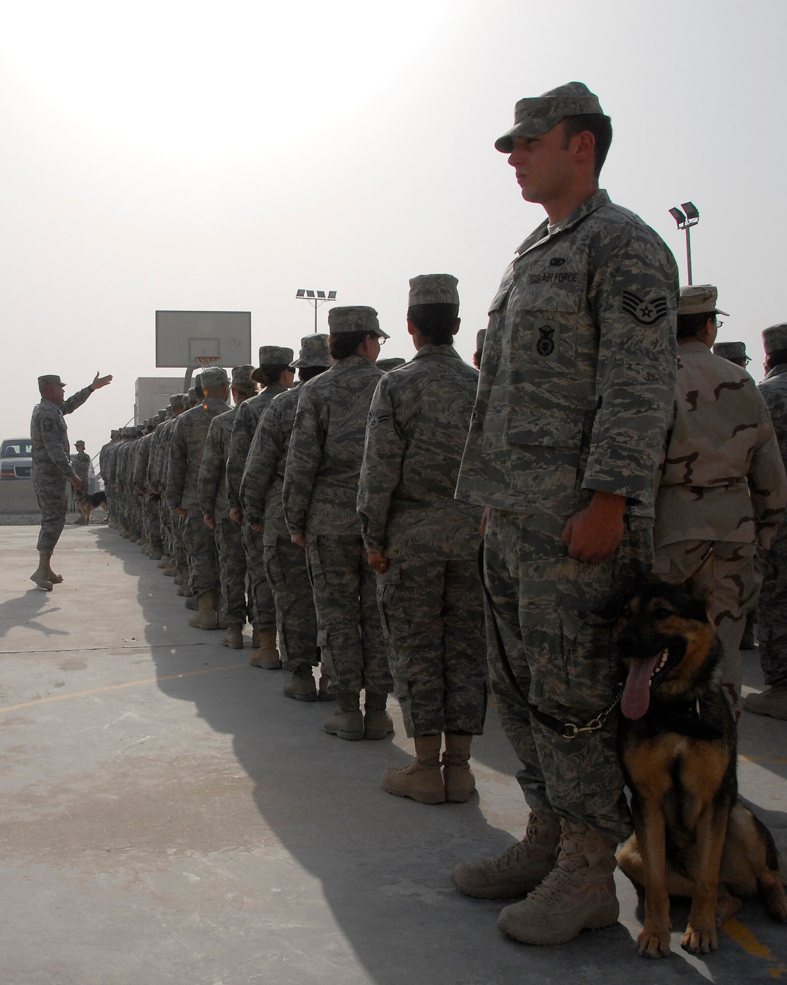 SOUTHWEST ASIA – Staff Sgt. Andrew Freytag, a K-9 handler, and Bady, his military working dog partner from the 386th Expeditionary Security Forces Squadron, keep eyes-front while Senior Master Sgt. Paul Yecke, the first sergeant for the 386th Expeditionary Mission Support Group, sizes up a formation of more than 270 Airmen for an expedited retreat ceremony April 25, 2008, at an air base in the Persian Gulf Region. (U.S. Air Force photo/Tech. Sgt. Michael O’Connor)