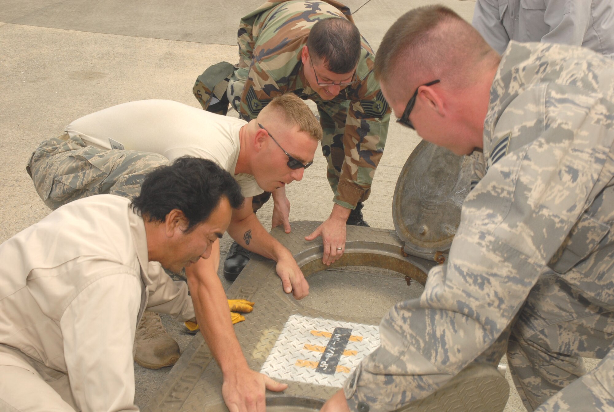 Members of the 18th Civil Engineering Squadron Liquid Fuels Flight remove the cover of a fuel pump at Kadena Air Base, Japan, April 22. The team routinely inspects the liquid fuel systems across the Kadena flightline. The flight maintains and periodically cleans more than 30 fuel storage tanks, some with a capacity of four million gallons.