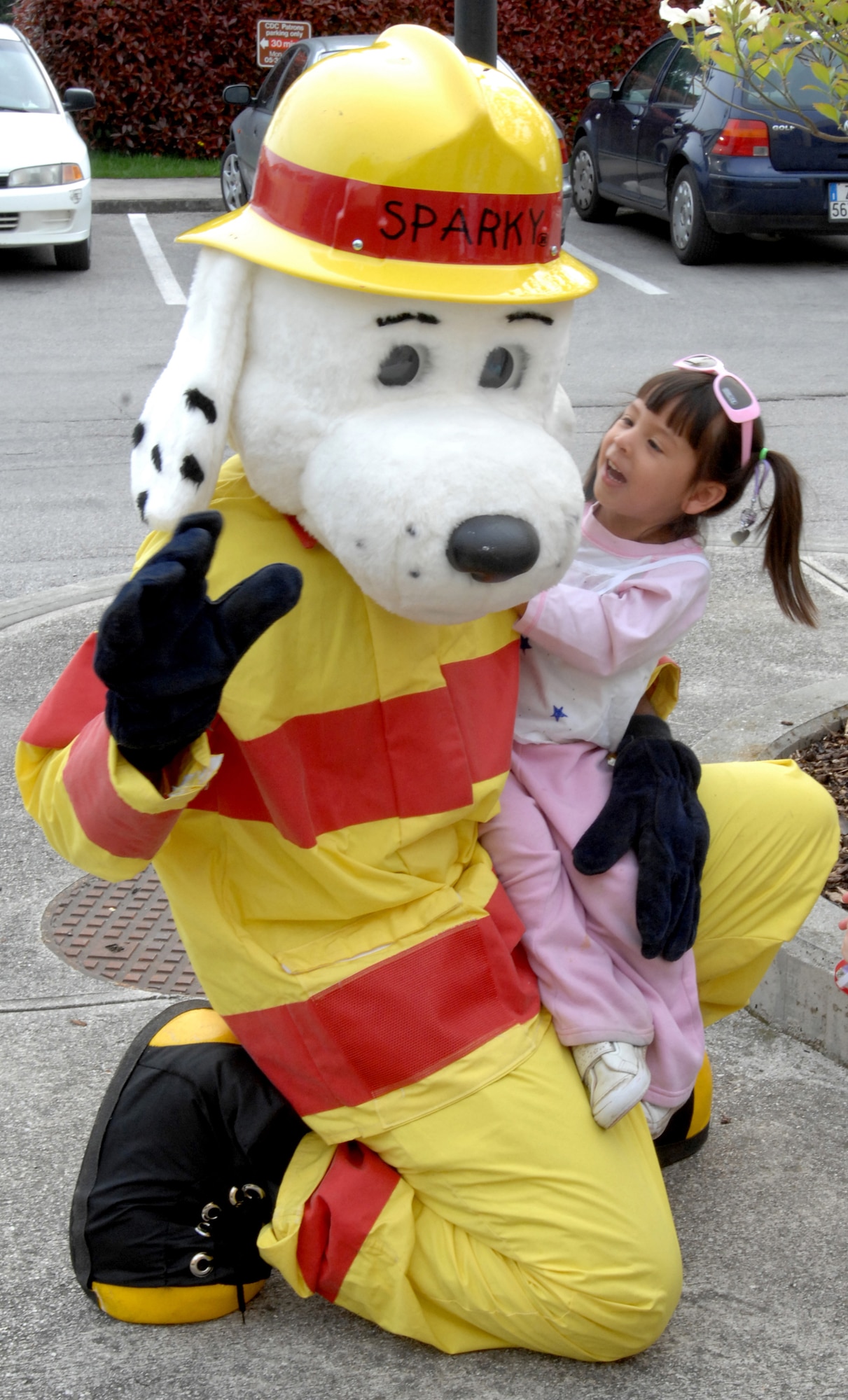 AVIANO AIR BASE, Italy--Lilianna Rodriguez pets Sparky the firefightin' dog during the month of the military CDC parade at Area 1. A firetruck, Sparky the dog, and 31st Security Forces personnel helped escort the children during the parade. (U.S. Air Force photo/Airman 1st Class Tabitha Mans).