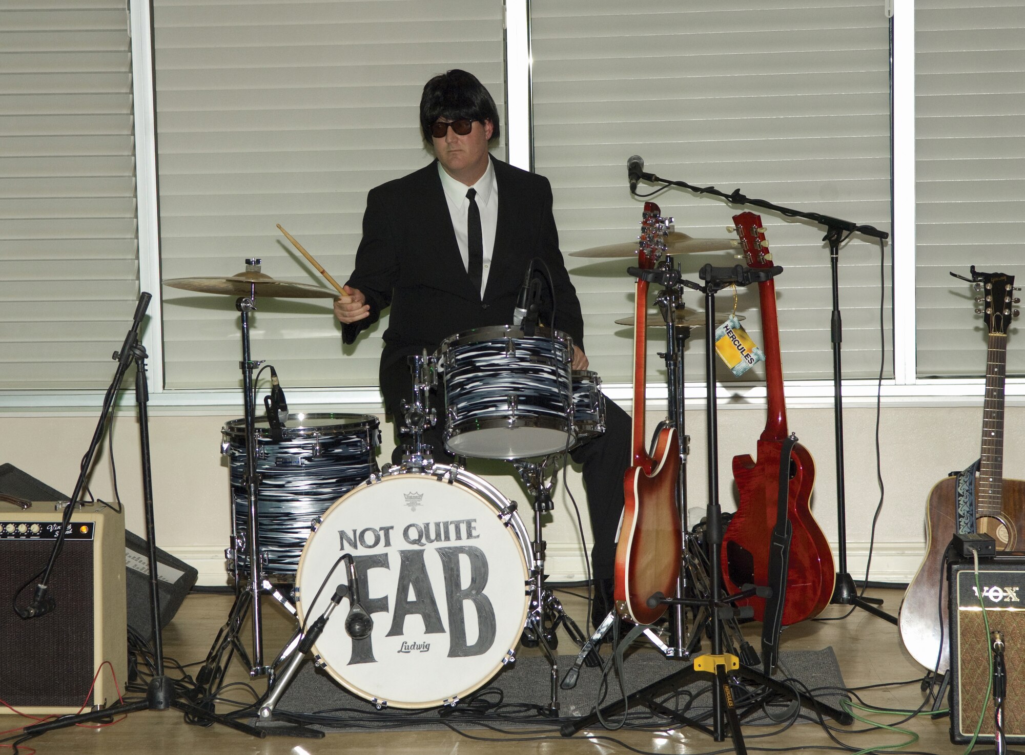 Chief Master Sgt. Jeffrey Fitzpatrick, former 719th Maintenance Squadron member, plays the drums alongside his three other band mates in the "Not Quite Fab" band at the 719th MXS farewell party earlier this month.