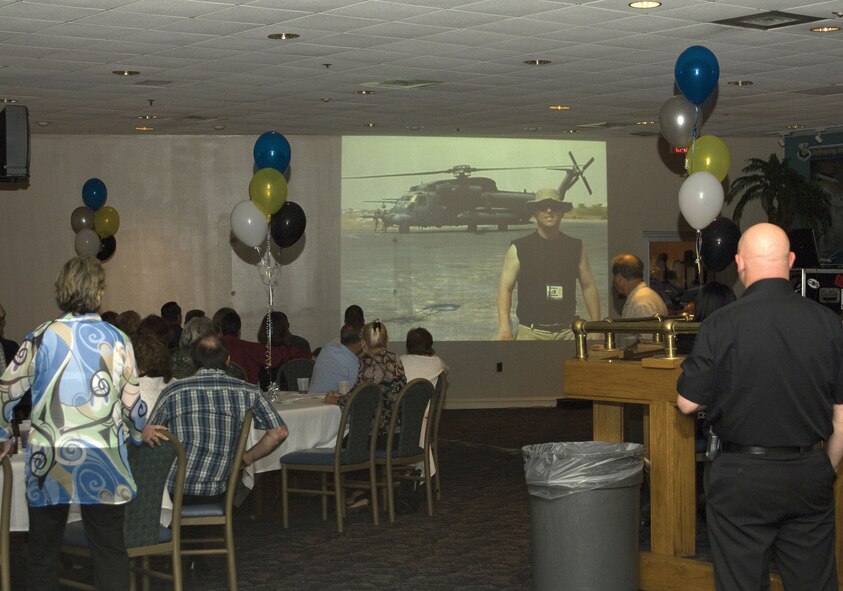 Friends, family and members of the 719th Maintenance Squadron watch a slideshow presentation at a party held in the unit's honor at the Eglin Air Force Base Officers' Club April 5. The presentation, arranged by Master Sgt. Charles McBride, former 719th MXS member, was composed of photos, videos and music highlighting the squadron's members in action through the years. (U.S. Air Force Photo/Mike Fleck)