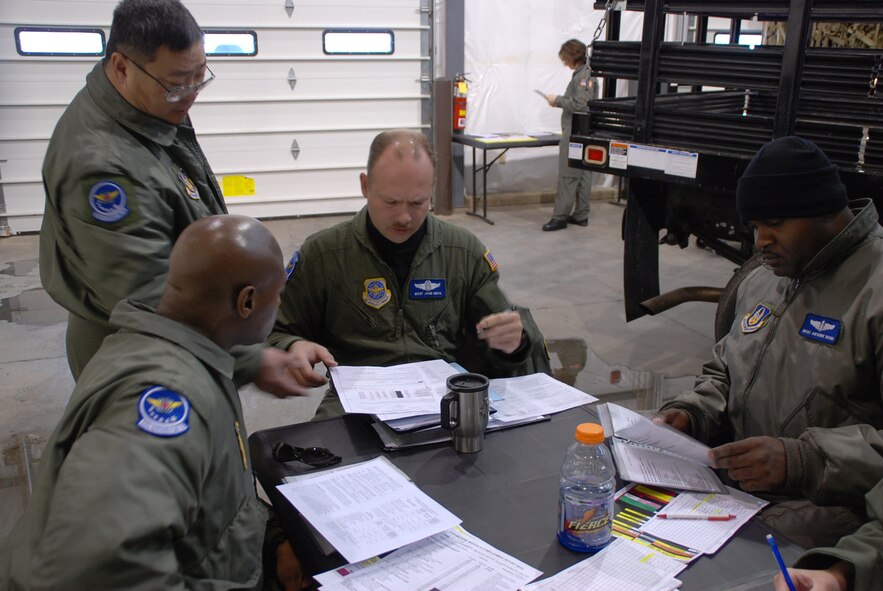 932nd Airlift Wing members spent time on the ground getting ready before a flying mission...Reservists check their forms and supplies.  An Air Force Reserve C-130 from the 910th Airlift Wing at Youngstown came through Scott recently and picked up a 932nd Aeromedical Evacuation Squadron crew for training on the way to Texas.Teamwork on the ground and in the air help the mission become a success for these members of the 932nd Aeromedical vacuation Squadron.  Photo/Capt. Stan Paregien