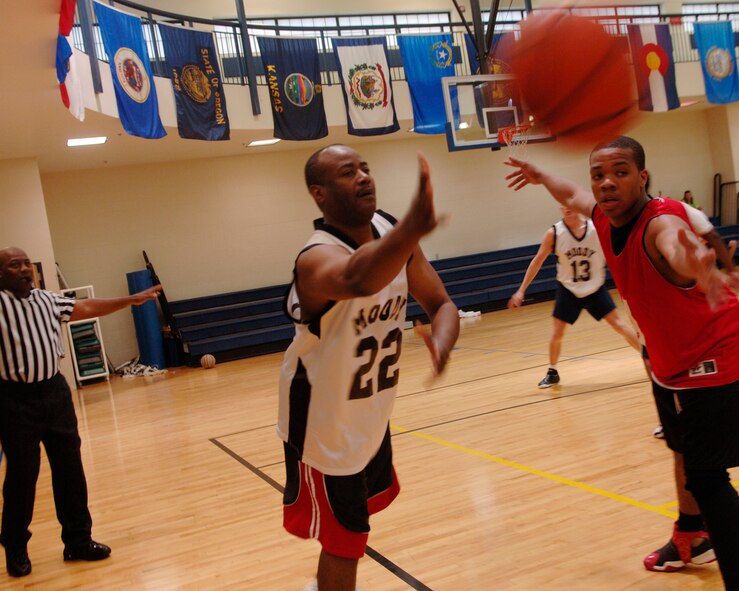MOODY AIR FORCE BASE, Ga. – Master Sgt. Larry Jackson, 23rd Communication Squadron client support administrator, passes the ball inbound while Airman 1st Class Marcus Bostic, 23rd Logistics Readiness Squadron inbound receiving clerk, defends him here April 24. Sergeant Jackson is a member of the Over 30 basketball team that went on to win over the intramural team 71-65. (U.S Air Force photo by Senior Airman Schelli Jones)