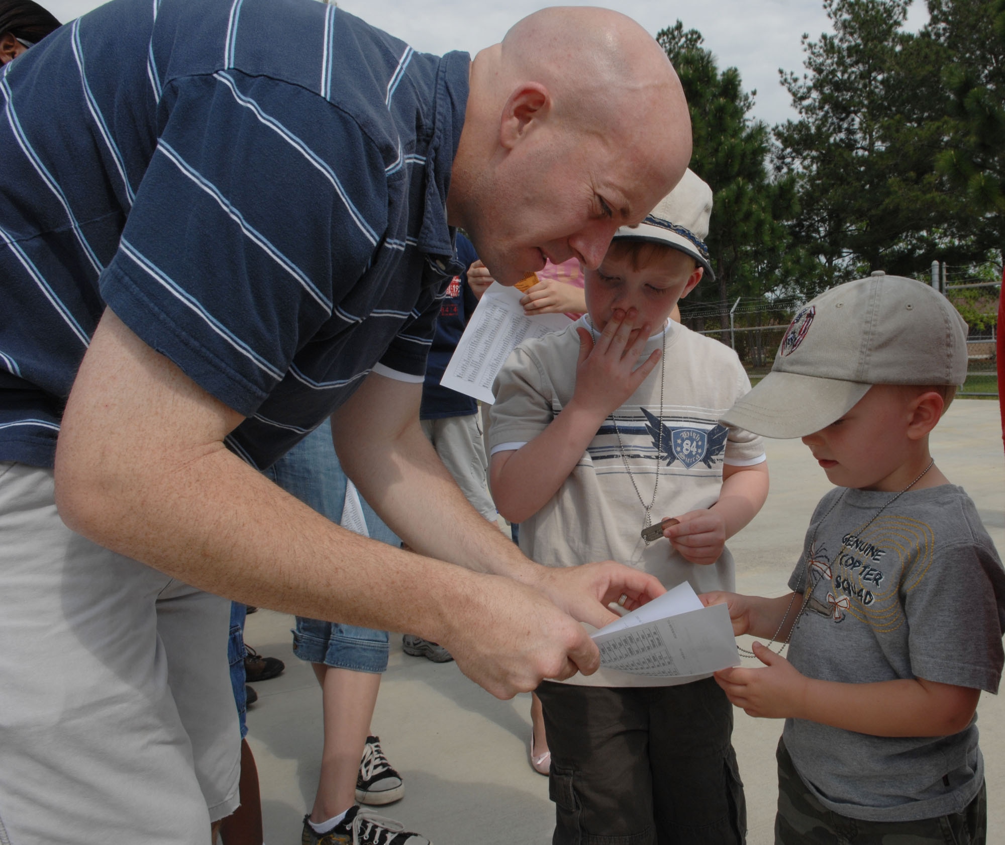 MOODY AIR FORCE BASE, Ga. – Capt. Michael Gallagher, 347th Rescue Group HC-130 Hercules navigator, explains the significance of deployment orders and dog tags to his sons, Aidan and James, during the kid’s deployment line here April 26.  The kid’s deployment line is a way to help children understand what their parents go through before deployment. (U.S. Air Force photo by Senior Airman Angelita Lawrence)