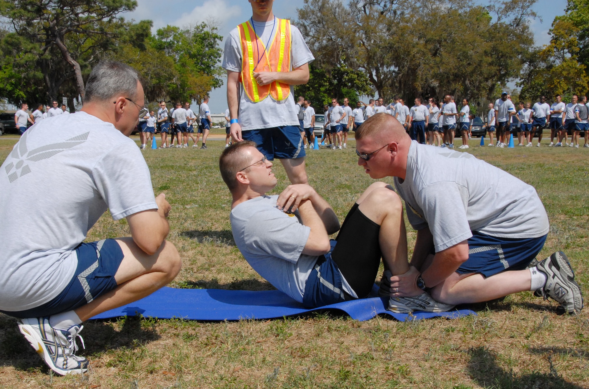 Tech Sgt. Brian Lowry, 16th Electronic Warfare Squadron, powers out some sit-ups, as Tech Sgt. Jason Sandusky, 16th EWS, counts and Lt. Col. Dean King, 16th EWS commander, encourages during the 53d EWG Sports Day April 25 at Eglin Air Force Base, Fla.  Photo by Staff Sgt. Samuel King Jr.