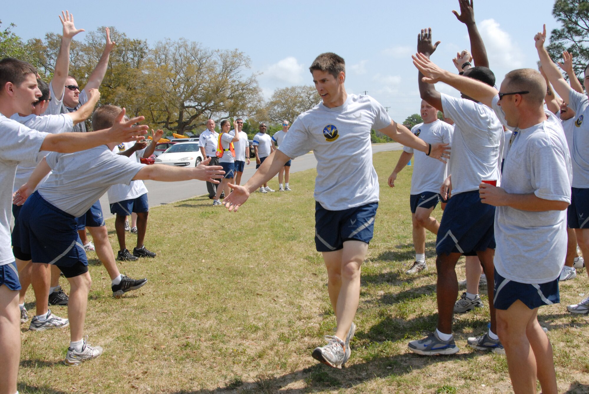 Staff Sgt. Robert O’Bannon, 16th Electronic Warfare Squadron, is congratulated by his squadron after completing the relay competition well ahead of the other two squadrons during the 53d EWG’s Sports Day April 25 at Eglin Air Force Base, Fla.  Photo by Staff Sgt. Samuel King Jr.