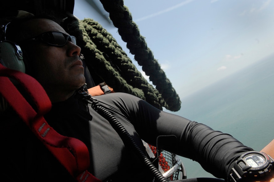 GULF OF MEXICO --  Tech. Sgt. Lem Torres, 38th Rescue Squadron pararescueman, keeps a look out for survivors during a rescue mission approximately 260 miles south of New Orleans, La., April 25. Responding to a request for support from the U.S. Coast Guard, two HH-60G Pave Hawk helicopters from the 41st Rescue Squadron and a 71st Rescue Squadron HC-130P King performed a 10-hour mission to retrieve a boatload of stranded migrants who had been picked up by a passing ship.  Five adults and one child were hoisted from the vessel and transported to the West Jefferson Medical Center in New Orleans, La. (U.S. Air Force photo by Senior Airman Gina Chiaverotti) 