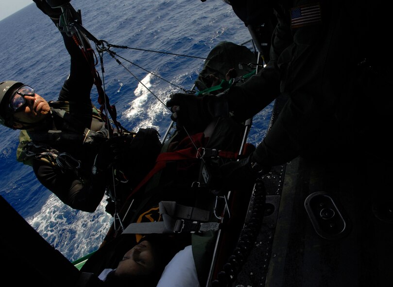 GULF OF MEXICO -- Tech. Sgt. Lem Torres, 38th Rescue Squadron pararescueman, hoists up a survivor on a litter during a search and rescue mission approximately 230 miles south of New Orleans, La., April 25. Responding to a request for support from the U.S. Coast Guard, two HH-60G Pave Hawk helicopters of the 41st Rescue Squadron and  a 71st Rescue Squadron HC-130P King performed a 10-hour mission to retrieve a boatload of stranded immigrants in distress that had been picked up by a passing ship.  (U.S. Air Force photo by Senior Airman Gina Chiaverotti) 