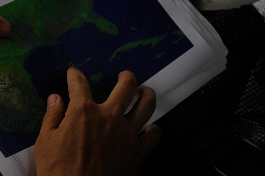 MOODY AIR FORCE BASE, Ga. -- Staff Sgt. Jason Broline, 38th Rescue Squadron pararescueman, shows Tech. Sgt. Lem Torres, 38th RQS PJ, the approximate location of survivors during a search and rescue mission here April 25. Responding to a request for support from the U.S. Coast Guard, two HH-60G Pave Hawk helicopters from the 41st Rescue Squadron and a 71st Rescue Squadron HC-130P King performed a 10-hour mission to retrieve a boatload of stranded Cuban migrants in distress that had been picked up by a passing ship. Five adults and one child were hoisted from the vessel and transported safely to a medical facility in New Orleans. (U.S. Air Force photo by Senior Airman Gina Chiaverotti) 
