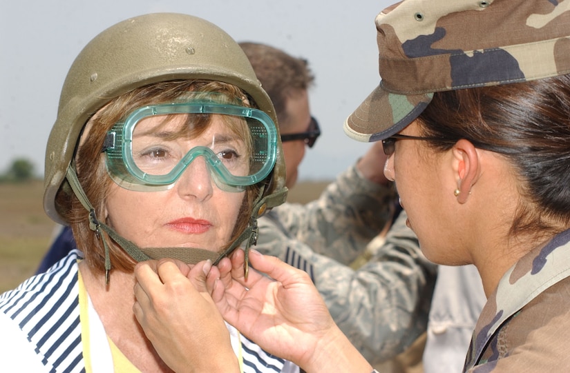 Air Force Capt. Kenya Colon, deputy director of logistics for Joint Task Force-Bravo, assists fitting a helmet on Joint Civilian Orientation Conference participant Nikki Clay. JCOC visited Soto Cano Air Base Apr. 24 as part of a tour of locations throughout the U.S. Southern Command area of responsibility. (Photo by Martin Chahin)