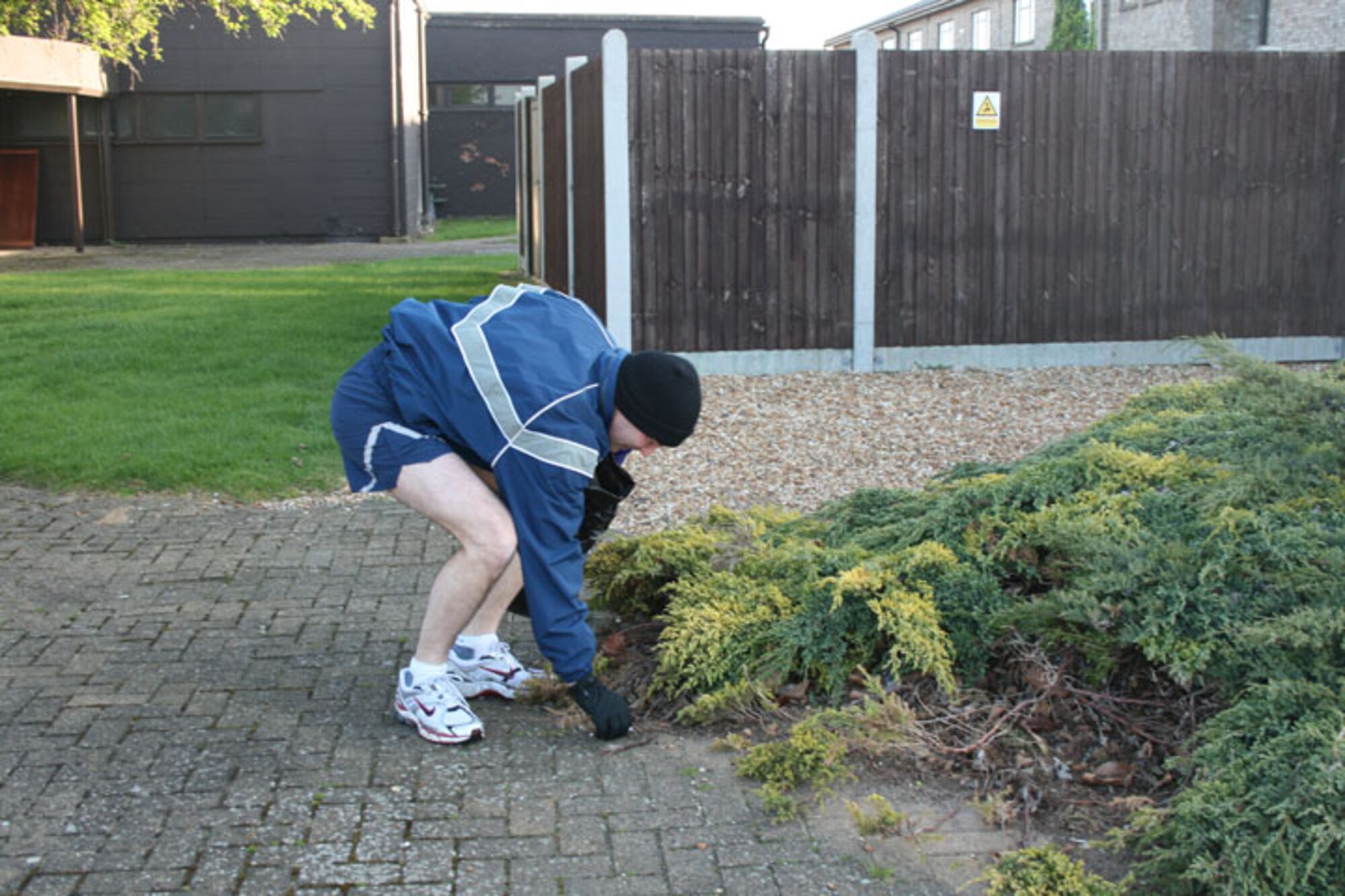 Lt. Col. Greg Urtso, 423rd Air Base Squadron commander, picks up trash outside a building at RAF Alconbury. Base members fanned out across the base to pick up trash and other debris as part of the Tri-Base Earth Day event.