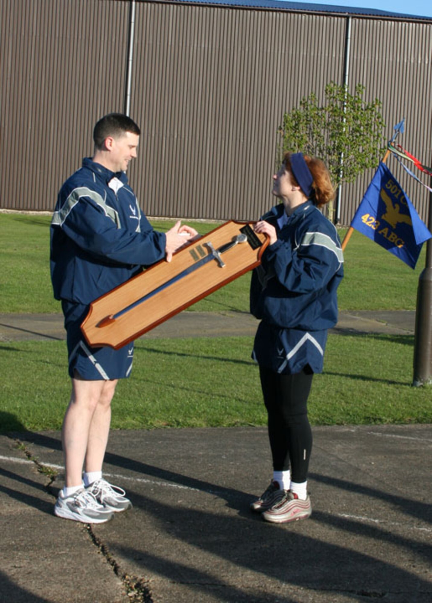 Capt. Aaron Guill, 423rd Security Forces commander, accepts the Warrior Run trophy from Col. Kimberly Toney, 501st Combat Support Wing commander. The squadron received the award for the fastest time during the Tri-Base Earth Day Warrior Run.