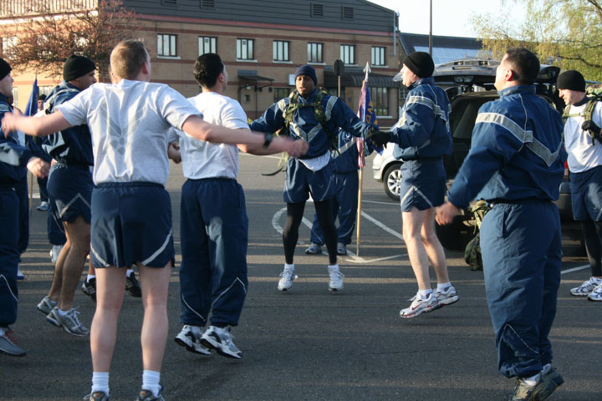 Members of the 423rd Air Base Squadron stop during a run for jumping jacks. The squadron participated in the Tri-Base Earth Day Warrior Run. Stopping points were placed along the route and contained such challenges as push-up and having select members load up with ruck sacks.