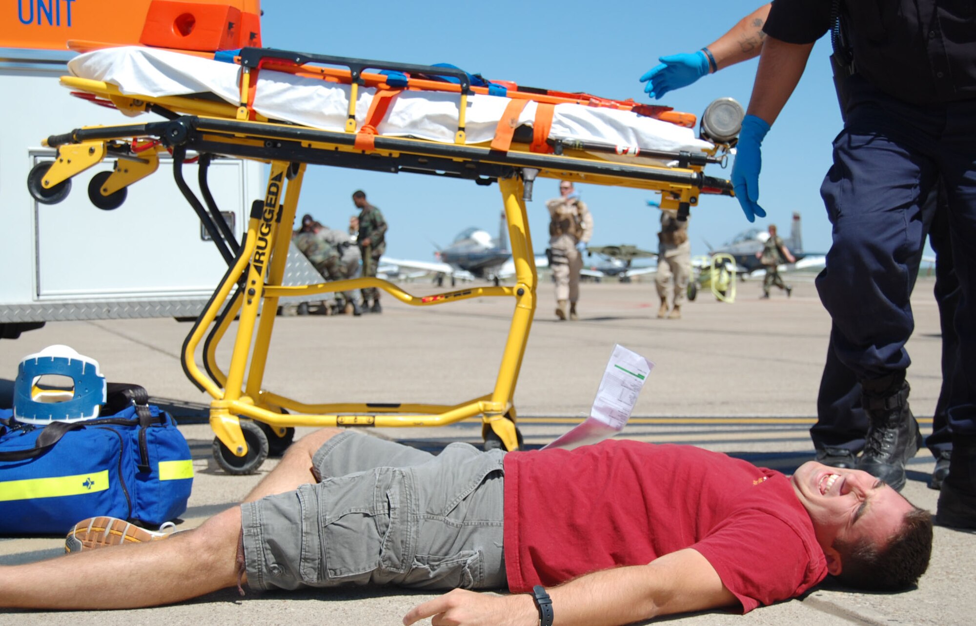 LAUGHLIN AIR FORCE BASE, Texas – A simulated victim of the replica plane crash lies on the ground while emergency response teams prepare to safely transfer him into an ambulance during an exercise here April 18. Laughlin conducted multiple exercises to prepare for an upcoming air show May 10. (U.S. Air Force photo by Airman 1st Class Sara Csurilla)