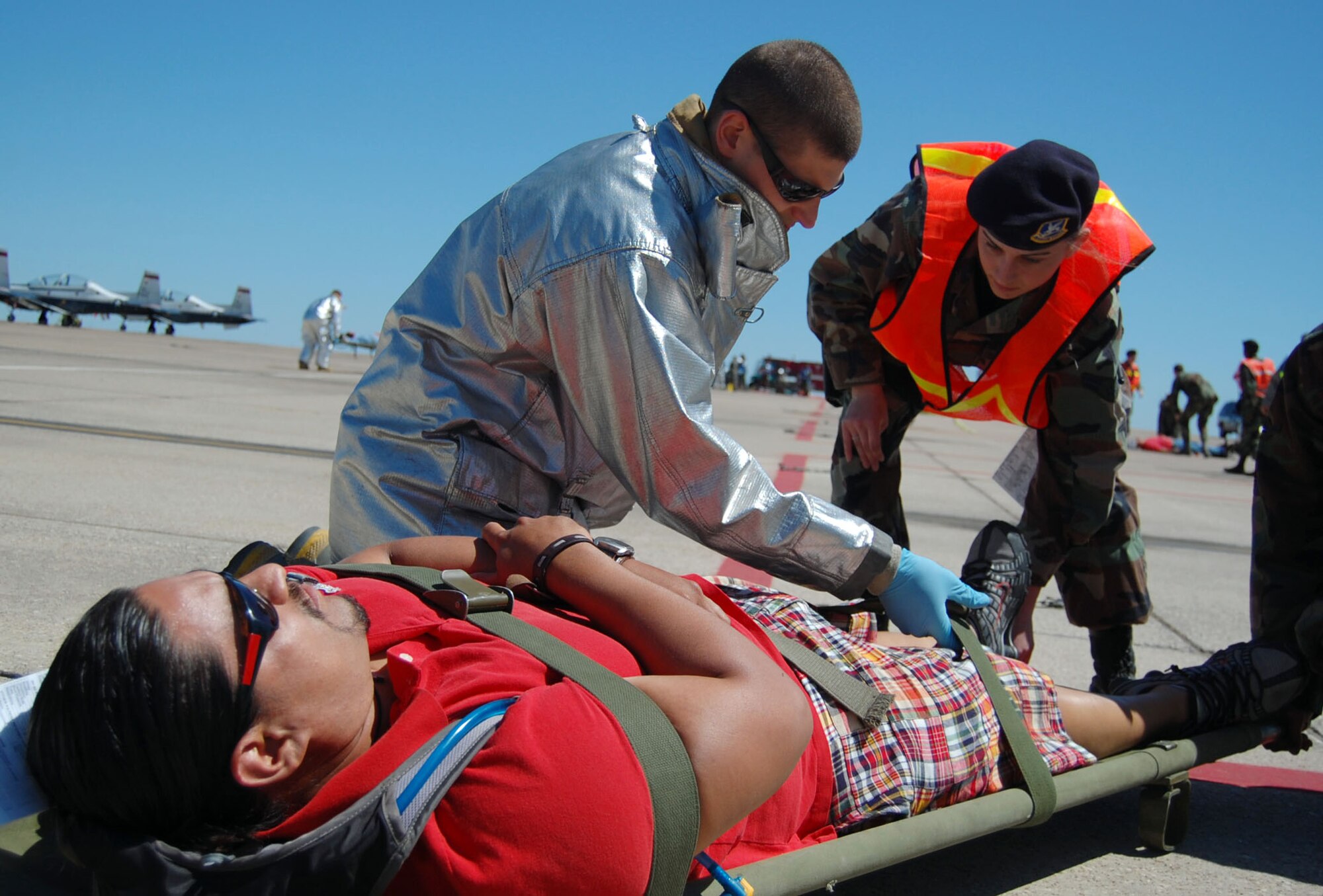 LAUGHLIN AIR FORCE BASE, Texas – Senior Airman Nick Powanda, Laughlin Fire Department and Airman 1st Class Ashley Jackson, 47th Security Forces Squadron, secure a simulated injured member on a stretcher after a mock plane crash on the flight line during an exercise conducted here April 18. Laughlin conducted multiple exercises to prepare for an upcoming air show May 10. (U.S. Air Force photo by Airman 1st Class Sara Csurilla)