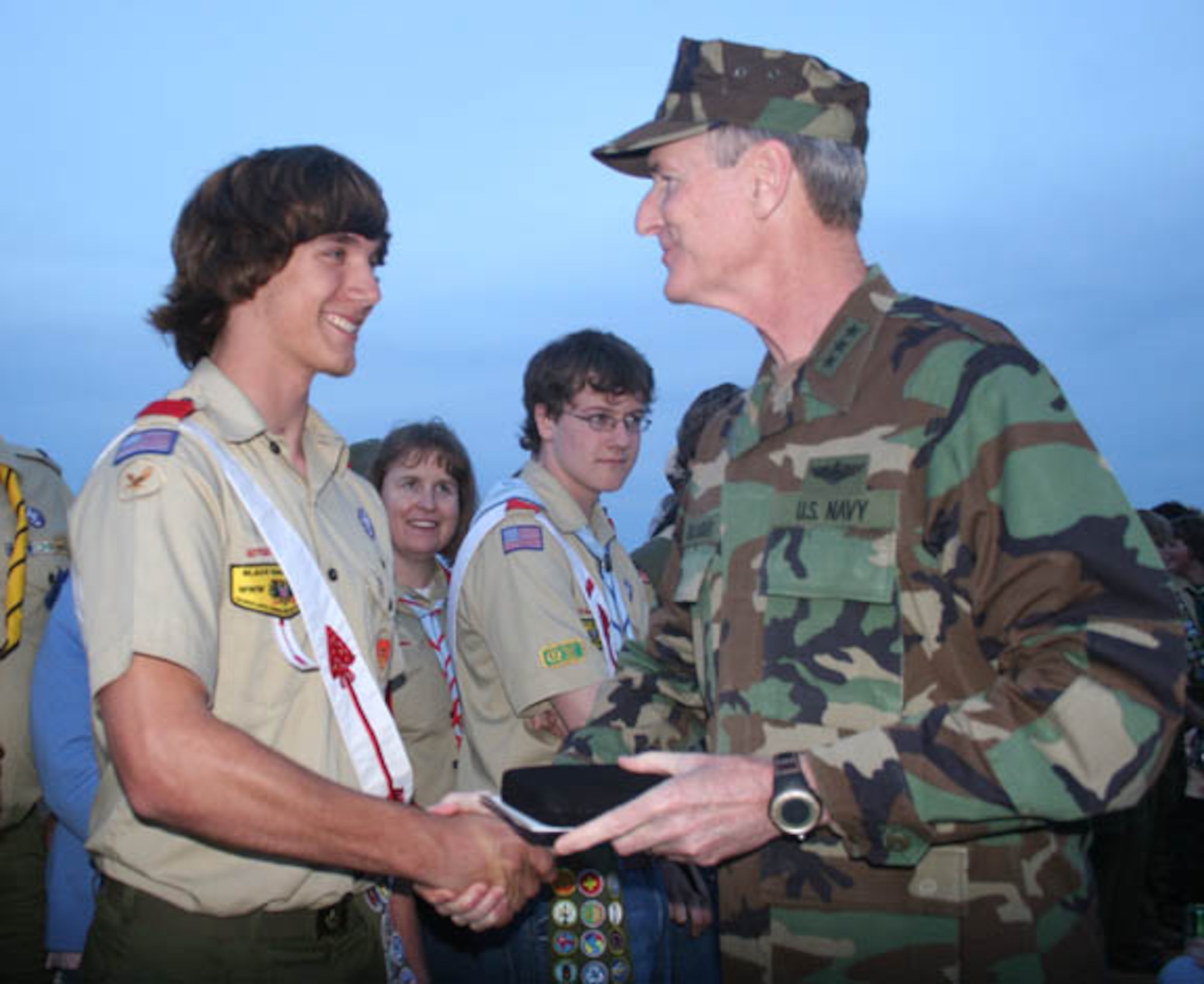 OMAHA BEACH, France -- U.S. European Command deputy commander Vice Adm.
Richard Gallagher congratulates Daniel Demers from Boy Scout Troop 165, Spangdahlem Air Base, Germany, for earning his Eagle Scout rank.
Gallagher recognized 31 new Eagle Scouts during the Boy Scouts of America Transatlantic Council Normandy Camporee bonfire on Omaha Beach, France, April 26, 2008. More than 3,600 Boy Scouts, Cub Scouts, Venture Scouts and family members participated in this year's Normandy camporee, which is held every three years and included scouts from as near as Brussels, Belgium, and as far away as Budapest, Hungary. (Photo by Air Force Maj. Pamela A.Q. Cook)
