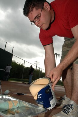 BOSSIER CITY, La. - Airman 1st Class Charles Alsobrook, of 2nd Logistics Readiness Squadron, pours paint into a paint tray while volunteering at the Red River Marine Institute April 10. The Airmen rebuilt recreation equipment at the facility and mentored students. (U.S. Air Force photo by Airman 1st Class Joanna M. Kresge)