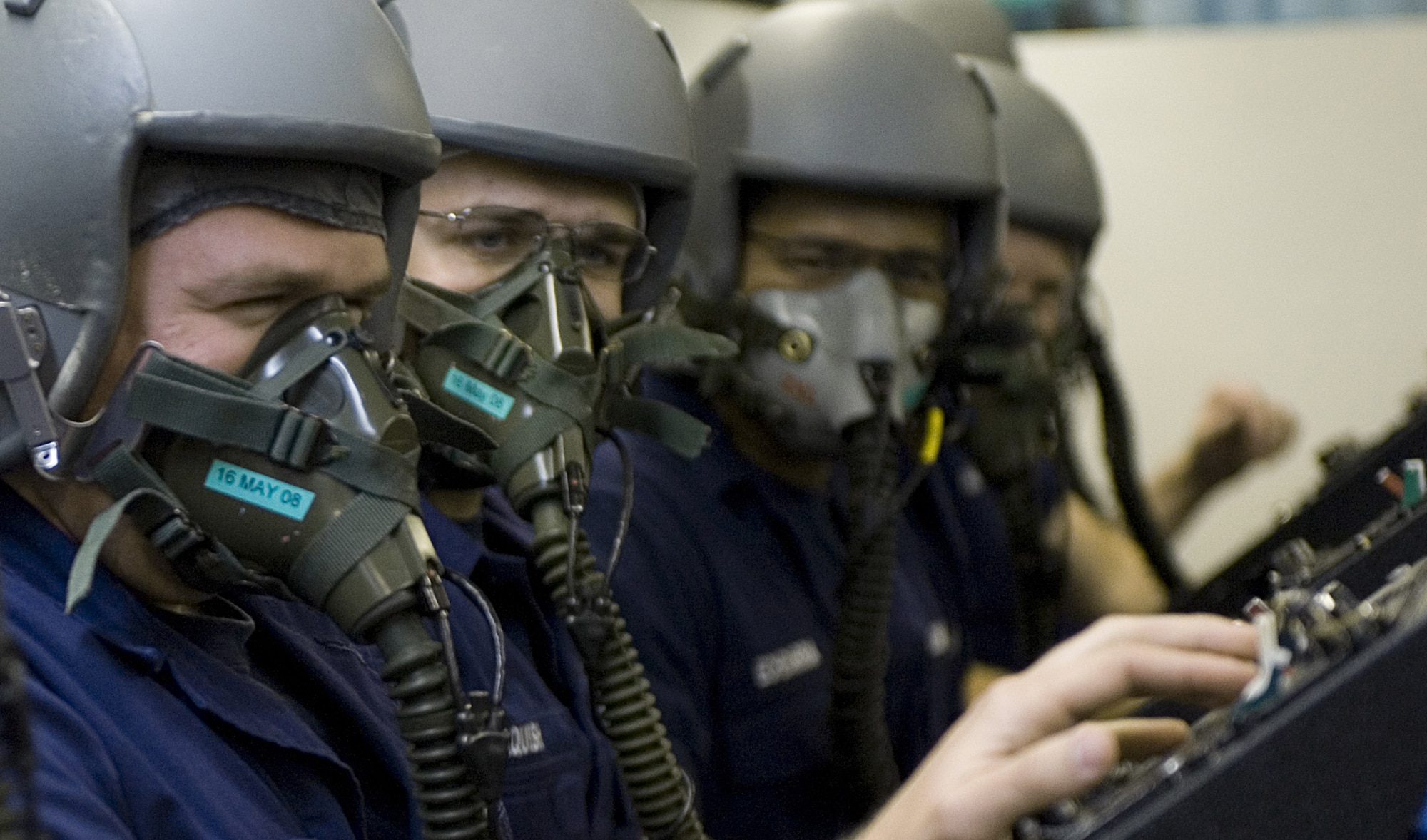 Airman Larry Kohl (left), a Coast Guard aviation maintenance technician student from Elizabeth City, N.J., Coast Guard Station, try's to speak to fellow students while performing a mask test during altitude chamber training March 23 at Langley Air Force Base, Va. While in the altitude chamber students are exposed to atmospheric conditions at 25,000 feet. Without the aid of an oxygen mask they experience symptoms of hypoxia, an oxygen deficiency of the tissue and blood cells that causes impairment of function at high altitudes. (U.S. Air Force Photo/Staff Sgt. Samuel Rogers) 