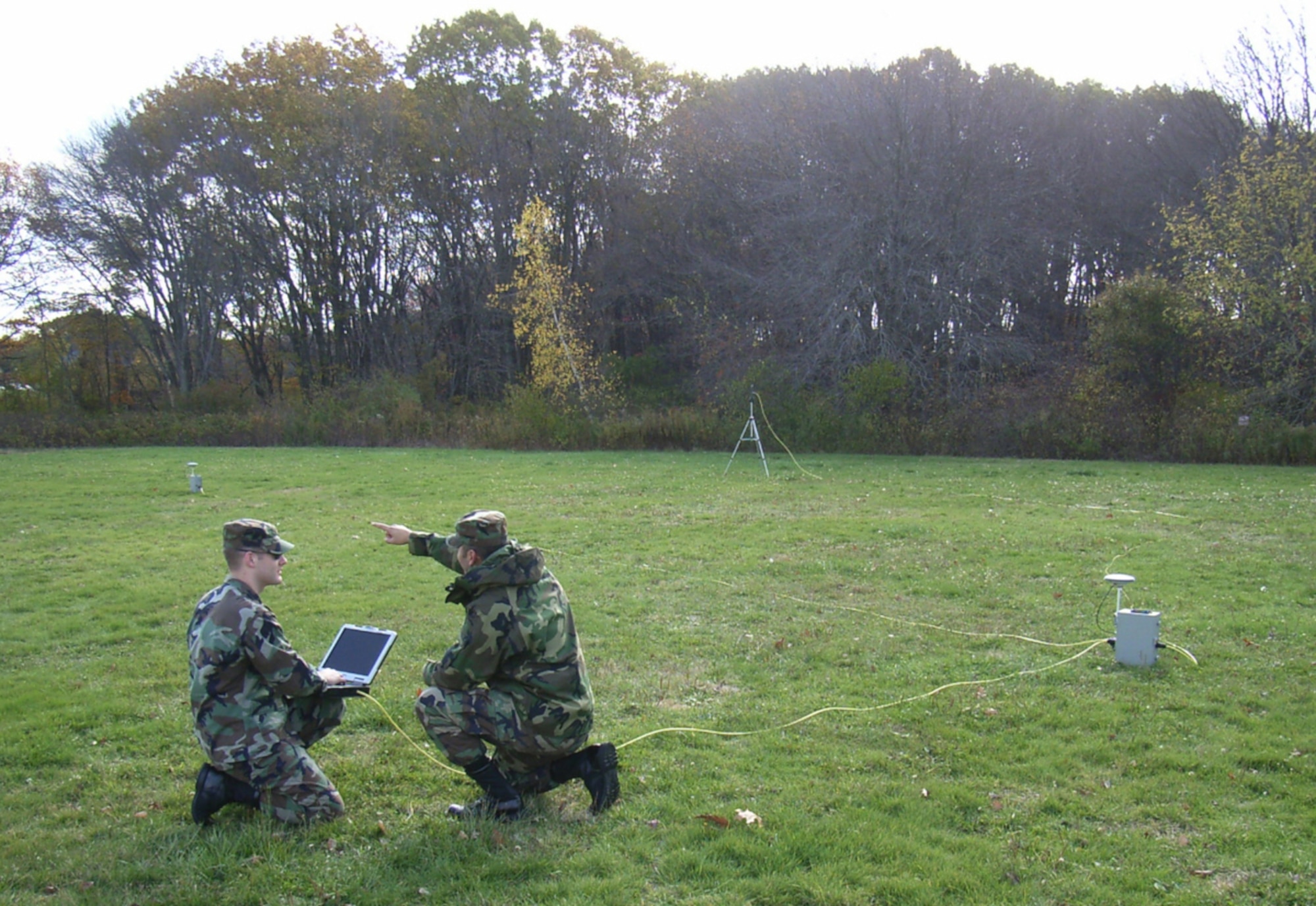 HANSCOM AFB, Mass. -- First Lt. Pat Ris (left) and 1st Lt. Juan Gherardy set up the Man-pack version of the Joint Precision Approach Landing System outside Hanscom  in November 2007. The equipment, which can be carried in two rucksacks, consists of two GPS antennas and receivers, a ruggedized notebook computer, networking hardware, and an aircraft data link. (Courtesy Photo)
