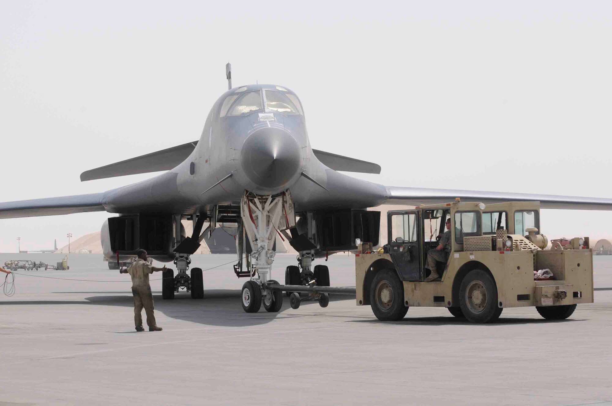 Airman 1st Class Samuel Philippe, 379 Expeditionary Maintenance Squadron, spots Staff Sgt. David Nygaard while he tows a B-1 Lancer at a Southwest Asia air base April 24. The B-1 is ready for a new mission after maintenance crew performed a 3 hour aircraft recovery.  (U.S. Air Force photo/Tech. Sgt. Johnny L. Saldivar)