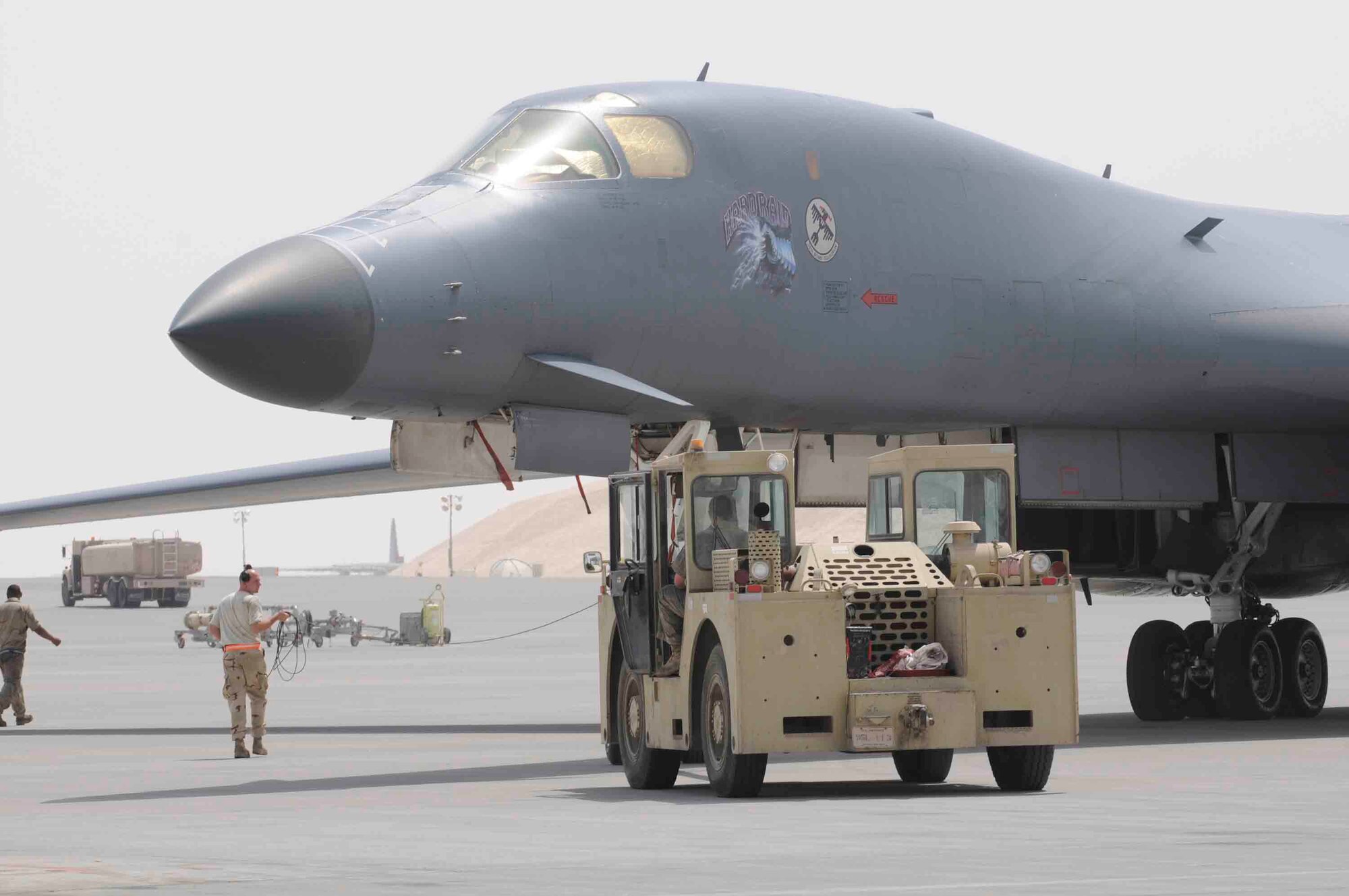 Staff Sgt. Phillip Sparks, 379 Expeditionary Maintenance Squadron, spots Staff Sgt. David Nygaard while he tows a B-1 Lancer at a Southwest Asia air base Apr. 24. The B-1 is ready for a new mission after maintenance crew performed a 3 hour aircraft recovery.  (U.S. Air Force photo/Tech. Sgt. Johnny L. Saldivar)