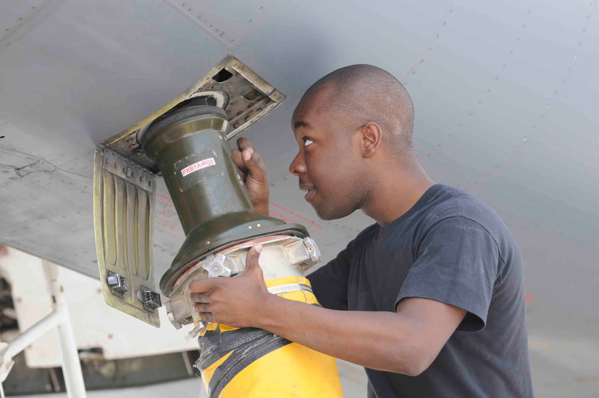 Senior Airman Craig Garrett, 379 Expeditionary Maintenance Squadron, hooks an air duct to a B-1 bomber aircraft at a Southwest Asia air base Apr. 24. Connecting cool air to aircraft prevents electrical system components from overheating.   He is deployed from Ellsworth Air Force Base, S.D.   (U.S. Air Force photo/Tech. Sgt. Johnny L. Saldivar)