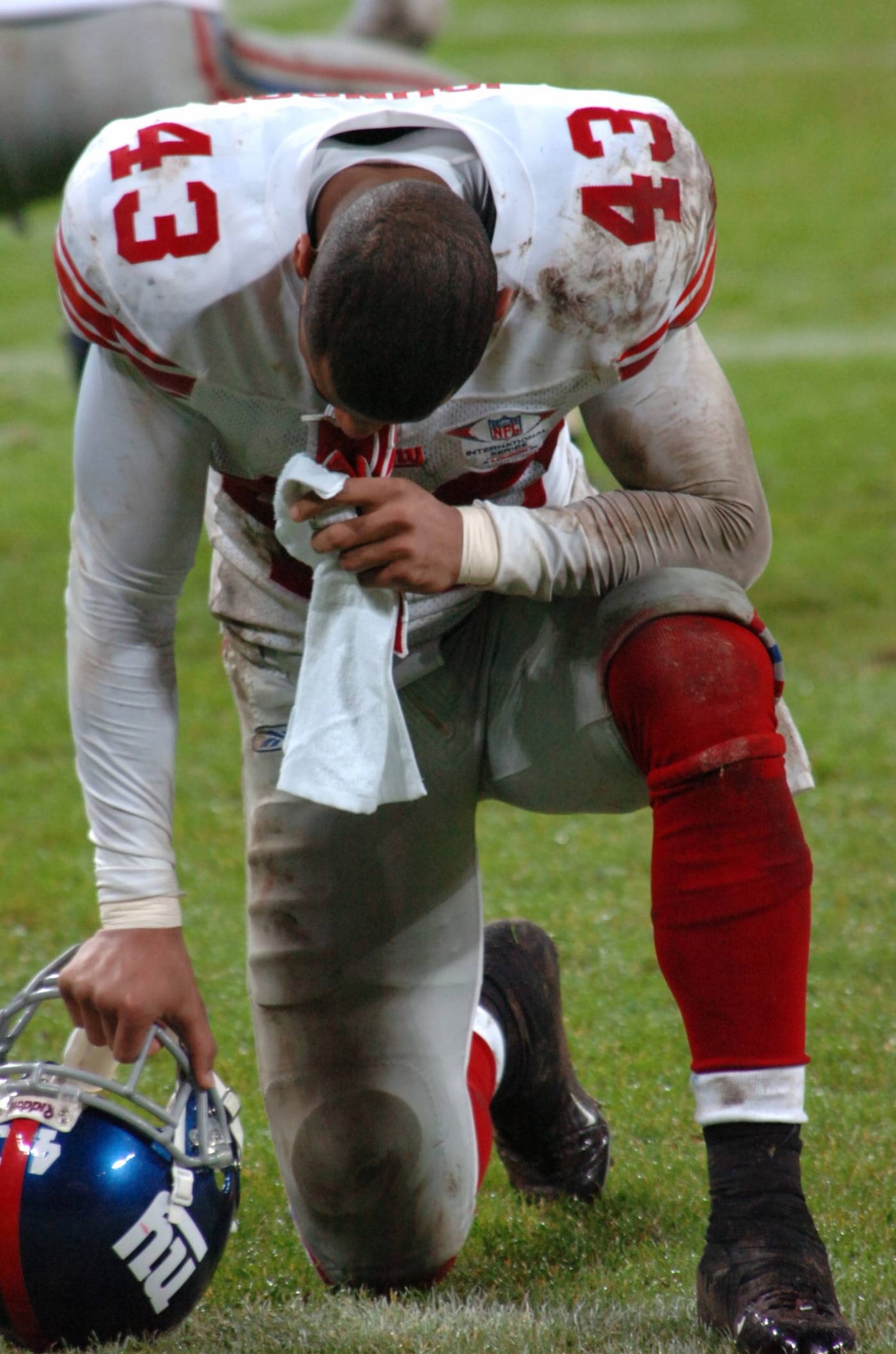 New York Giants rookie safety Michael Johnson says a prayer before the start of the second half of the first-ever NFL regular season game played in London, England.  Staff Sgt. Jocelyn Rich was the only military photographer given all-areas access during the October 2007 Miami Dolphins Vs. New York Giants game.  Staff Sgt. Rich accompanied the JIOCEUR Analytic Center Honor Guard who performed at the game.  (U.S. Air Force Photo by Staff Sgt. Jocelyn L. Rich)