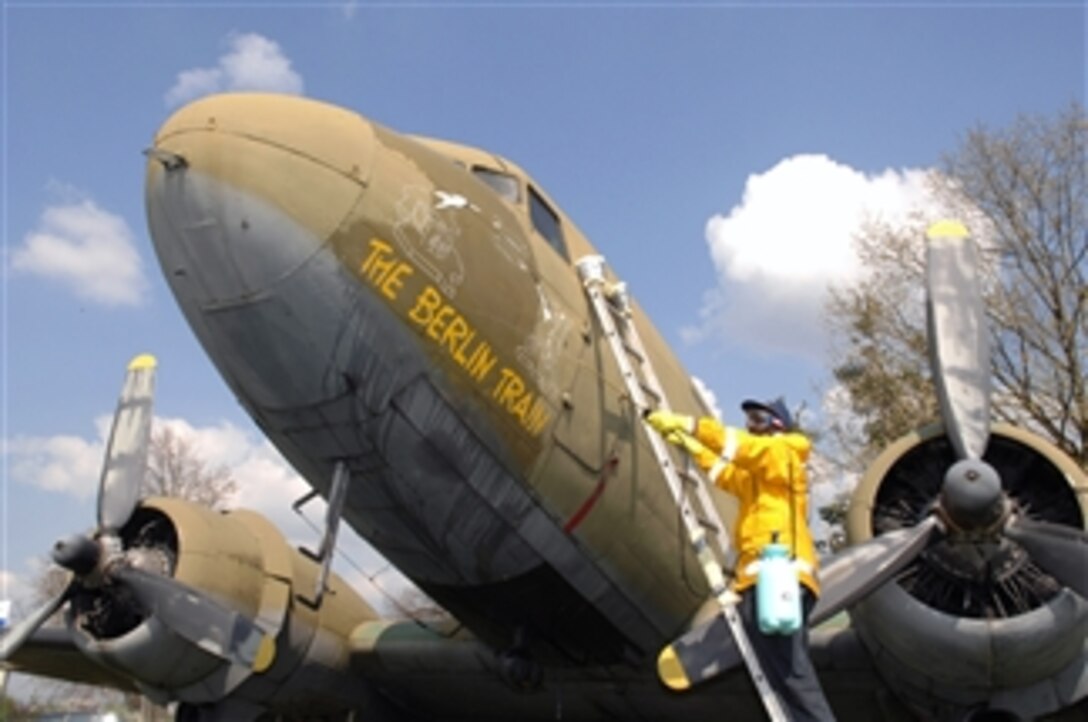 Air Force Staff Sgt. Federico Hudson cleans the nose art on a static C-54 aircraft on display at the Berlin Airlift Memorial site at the former Rhein Main Air Base near Frankfurt International Airport in Germany, April 23, 2008. Hudson and volunteers from Ramstein Air Base cleaned the aircraft for a Berlin Airlift 60th Anniversary Celebration to take place there in June.